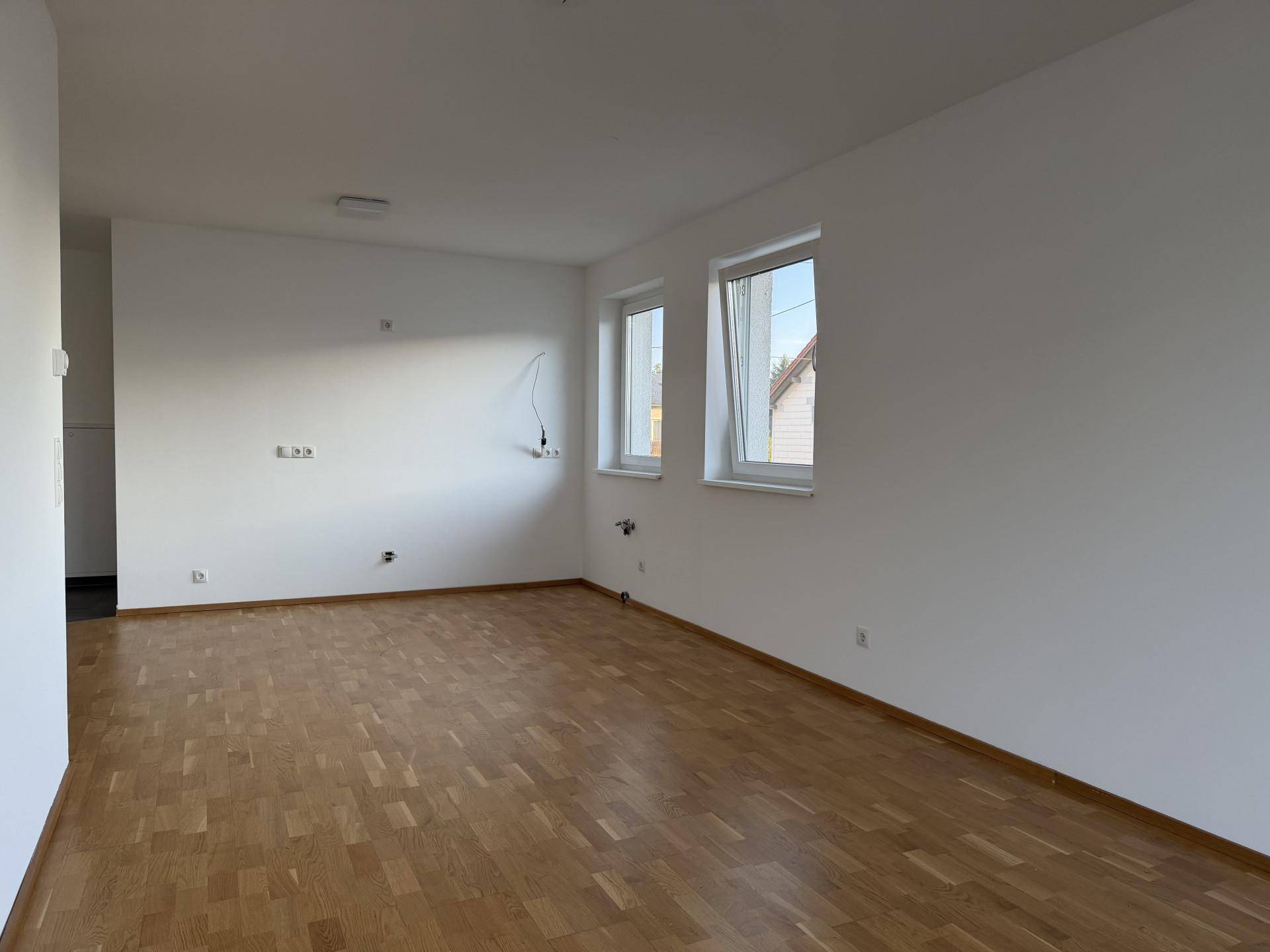 Geräumiger, heller Raum mit Parkettboden und zwei Fenstern, bereit zur individuellen Gestaltung.