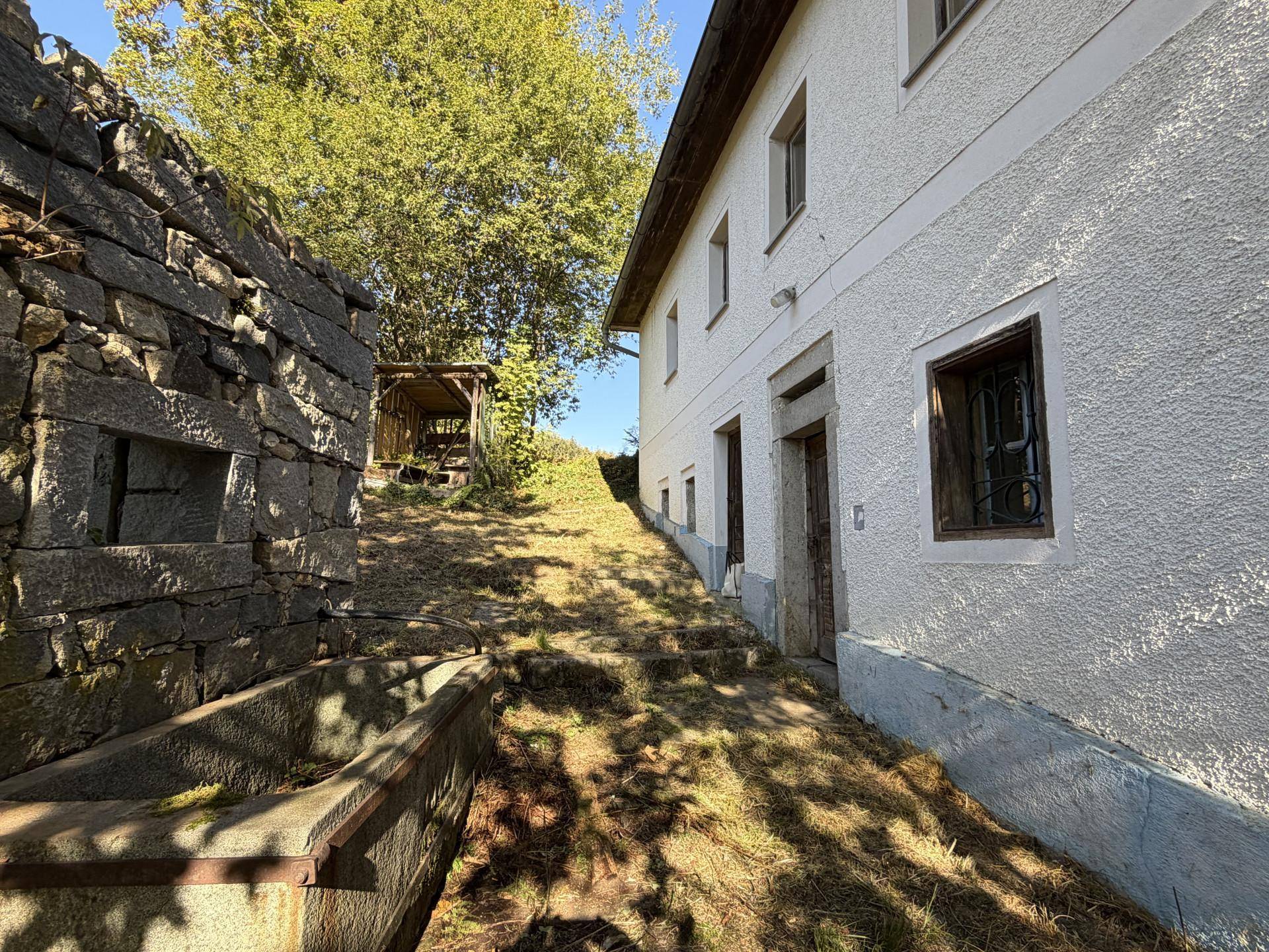 Schräge Ansicht eines historischen Gebäudes mit weißer Fassade und einem aufsteigenden Weg.