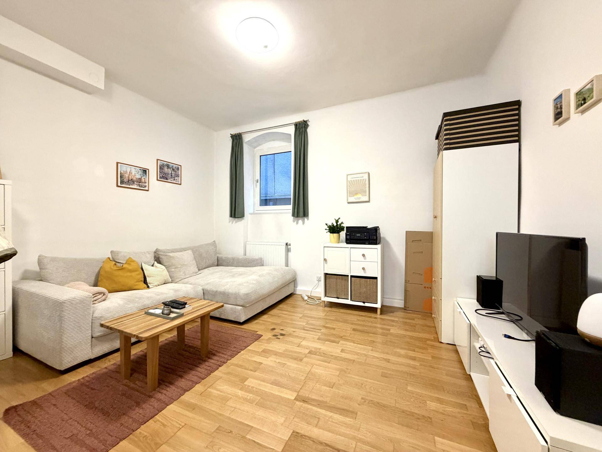 Gemütliches Wohnzimmer mit großem Ecksofa, Holzboden und moderner Einrichtung.