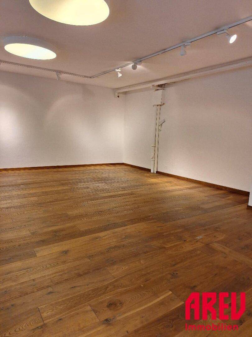 Geräumiger, leerer Raum mit hochwertigem Holzboden und weißen Wänden, bereit zur individuellen Gestaltung.