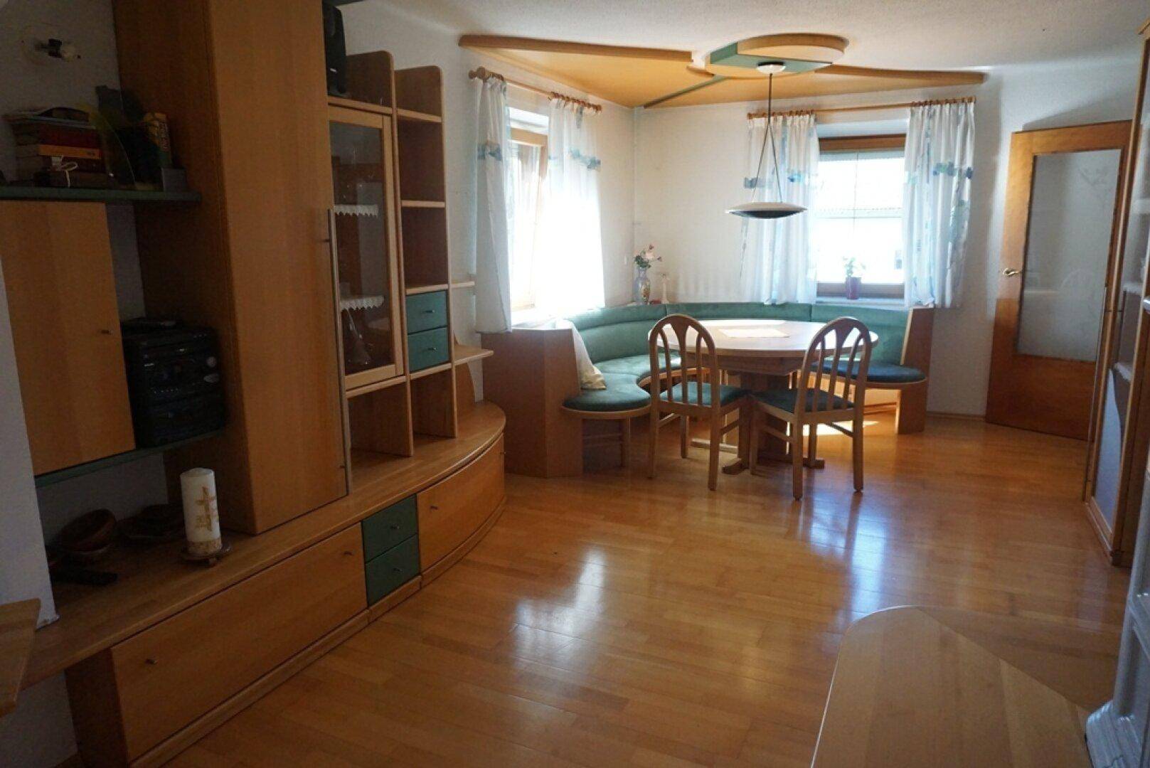 Heller Wohn-Essbereich mit Eckbank, Esstisch und passenden Holzmöbeln in traditionellem Stil.
