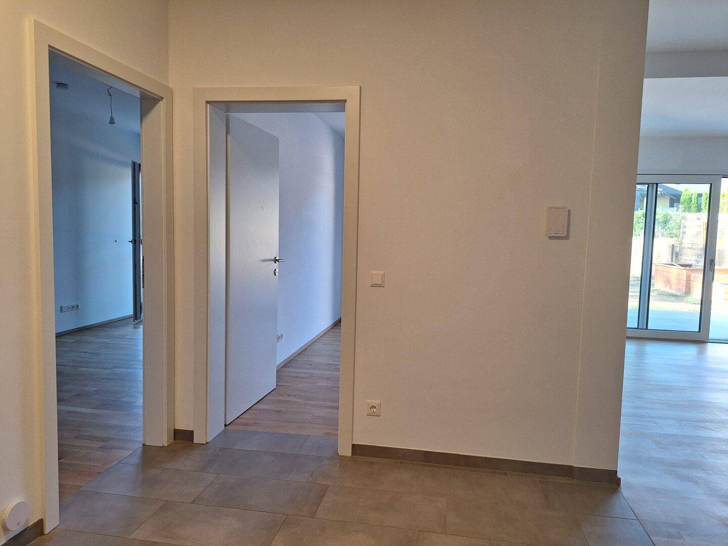 Heller Flurbereich mit gefliestem Boden und Zugang zu verschiedenen Räumen.