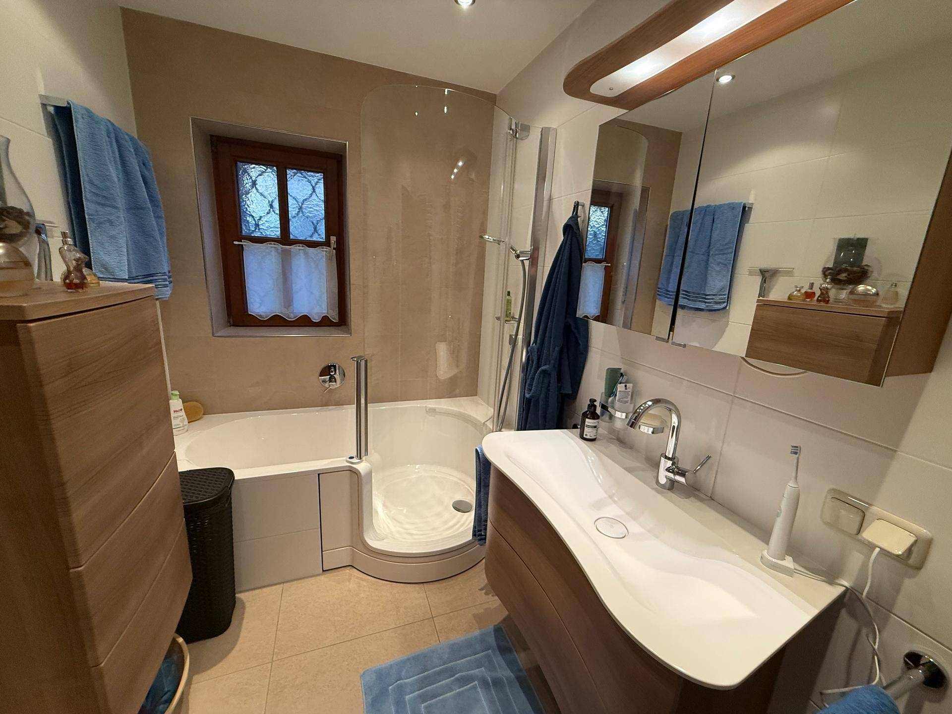 Modernes Badezimmer mit Dusche, Badewanne und stilvollem Waschtisch.