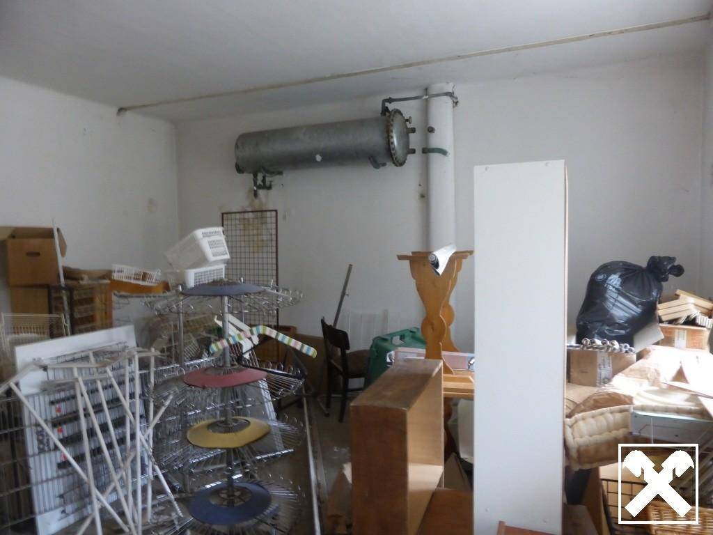 Abstellraum mit verschiedenen Gegenständen und einem großen Warmwasserboiler an der Wand.
