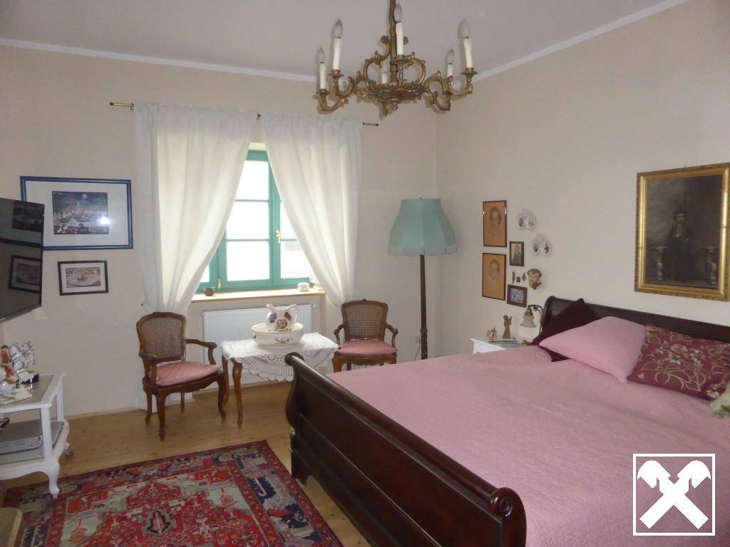 Geräumiges Schlafzimmer mit Doppelbett, Teppich und traditionellem Kronleuchter.