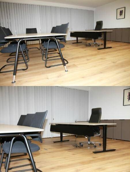 Heller Konferenzraum mit großem Tisch, Bürostühlen und Jalousien an den Fenstern, bietet eine professionelle Umgebung.