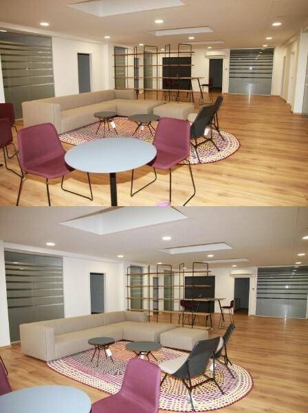 Geräumiger Lounge-Bereich mit bequemen Sofas, Tischen und einem großen Regal als Raumteiler, ideal für Entspannung.