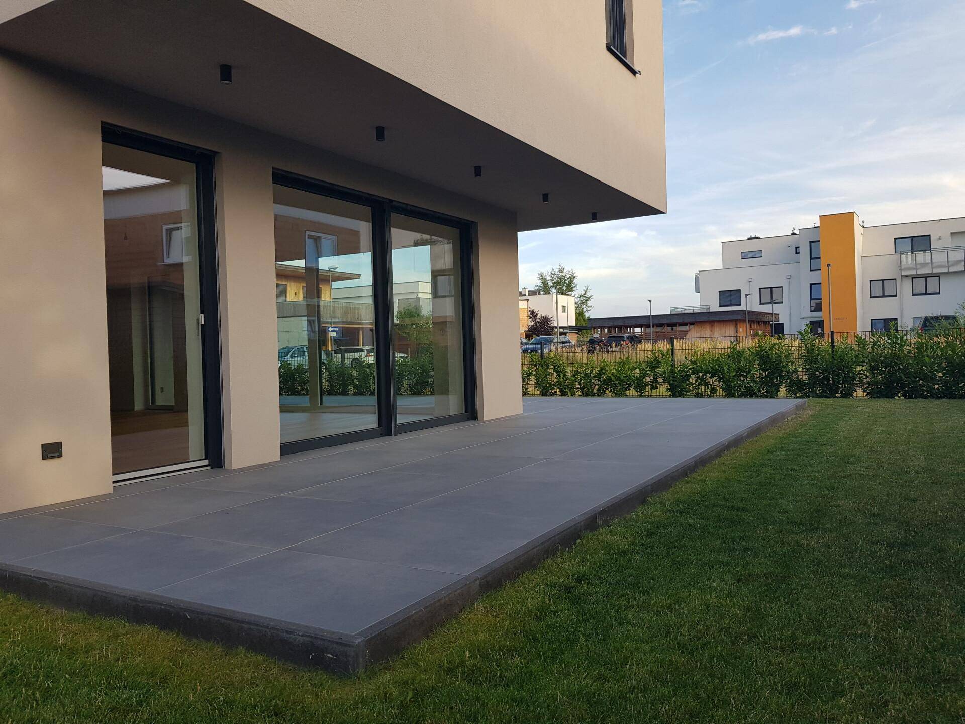 Großzügige, geflieste Terrasse mit direktem Zugang zum Garten und Blick auf die Umgebung.
