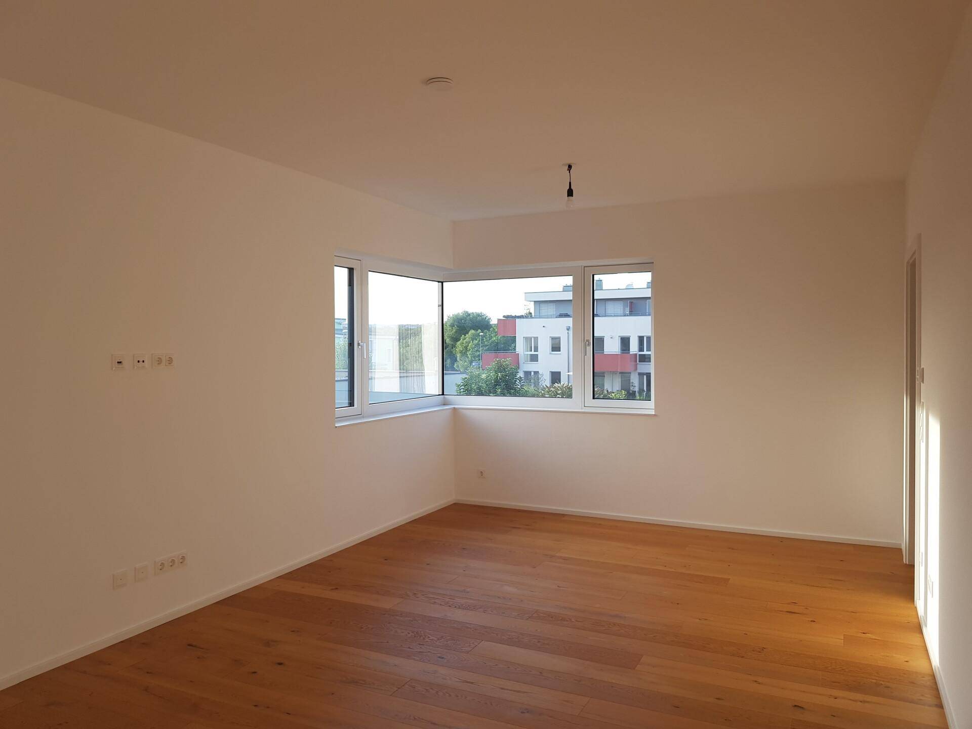 Helles Zimmer mit Eckfenstern, die einen weiten Blick auf die Umgebung bieten.