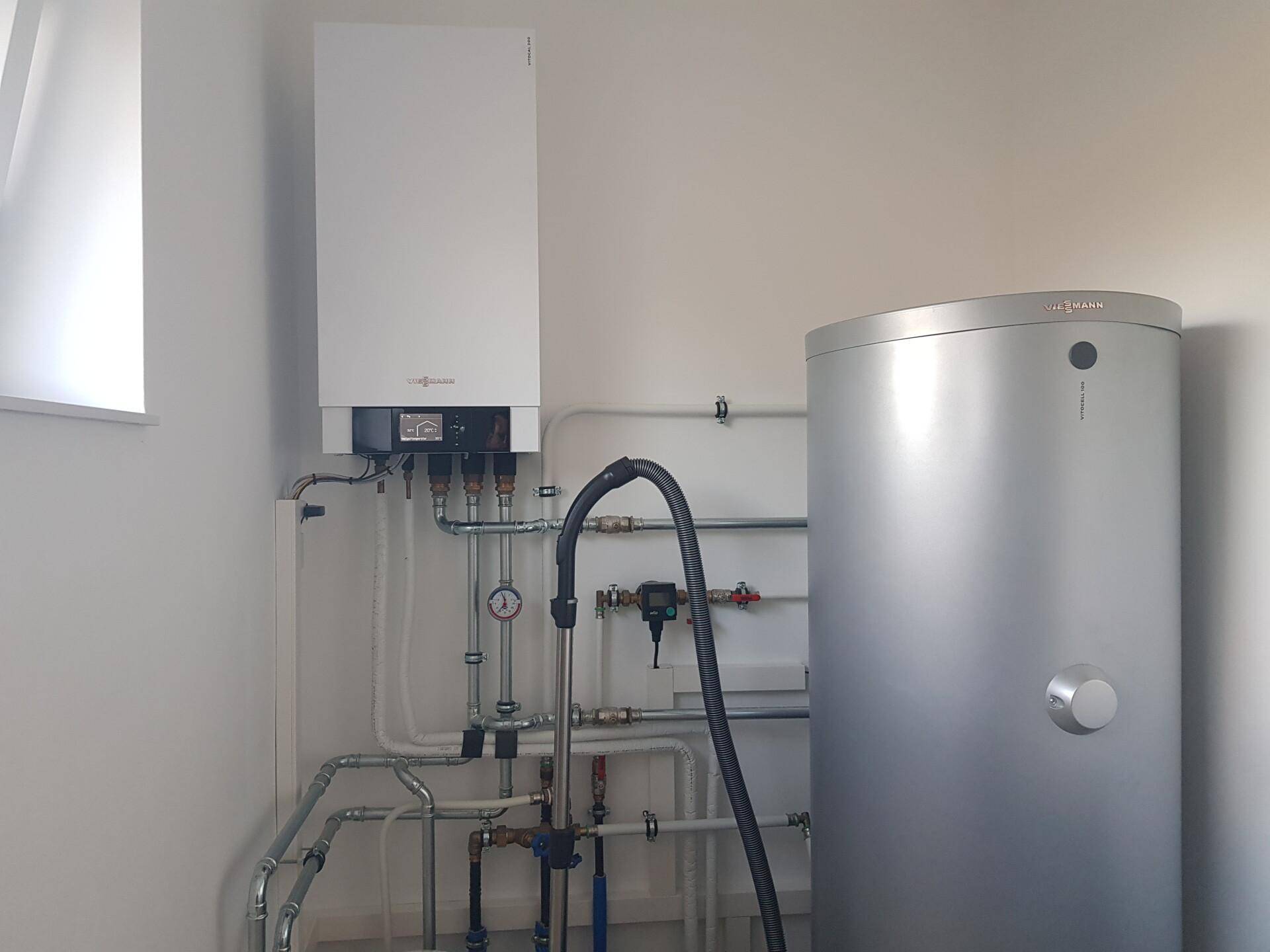 Technikraum mit moderner Heizungsanlage und Warmwasserspeicher für effiziente Energieversorgung.