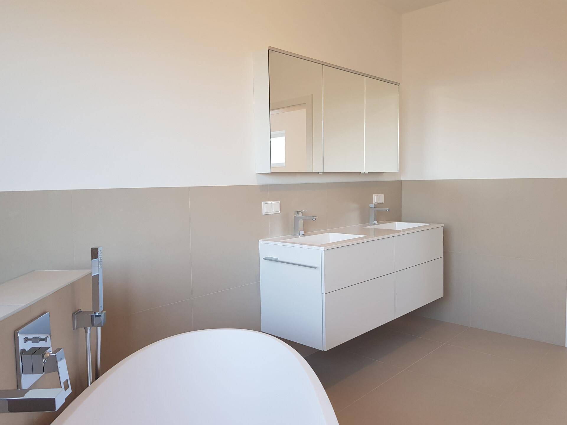 Modernes Badezimmer mit schwebendem Doppelwaschbecken und großem Spiegelschrank.