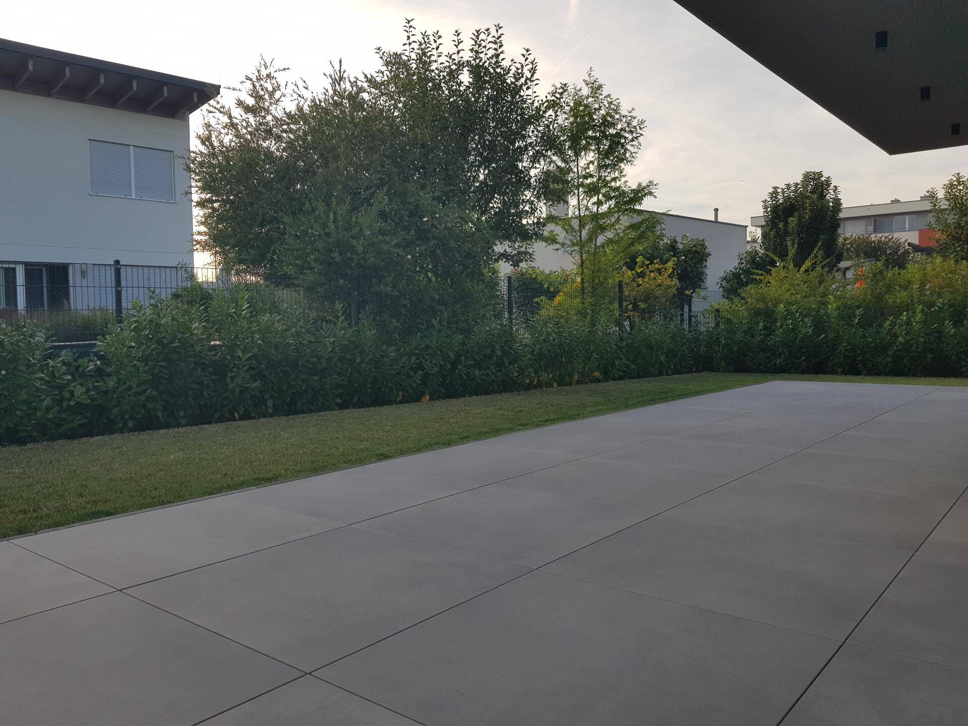 Weitläufige Terrasse mit angrenzendem Rasenbereich, ideal für Entspannung im Freien.