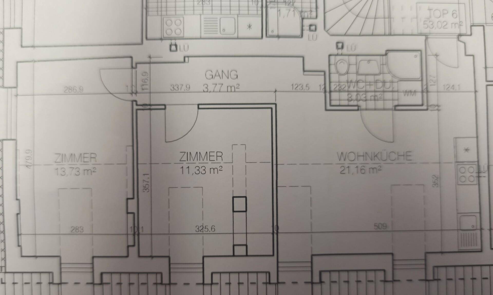 Grundriss einer Wohnung mit zwei Zimmern, Wohnküche, Gang und Bad.