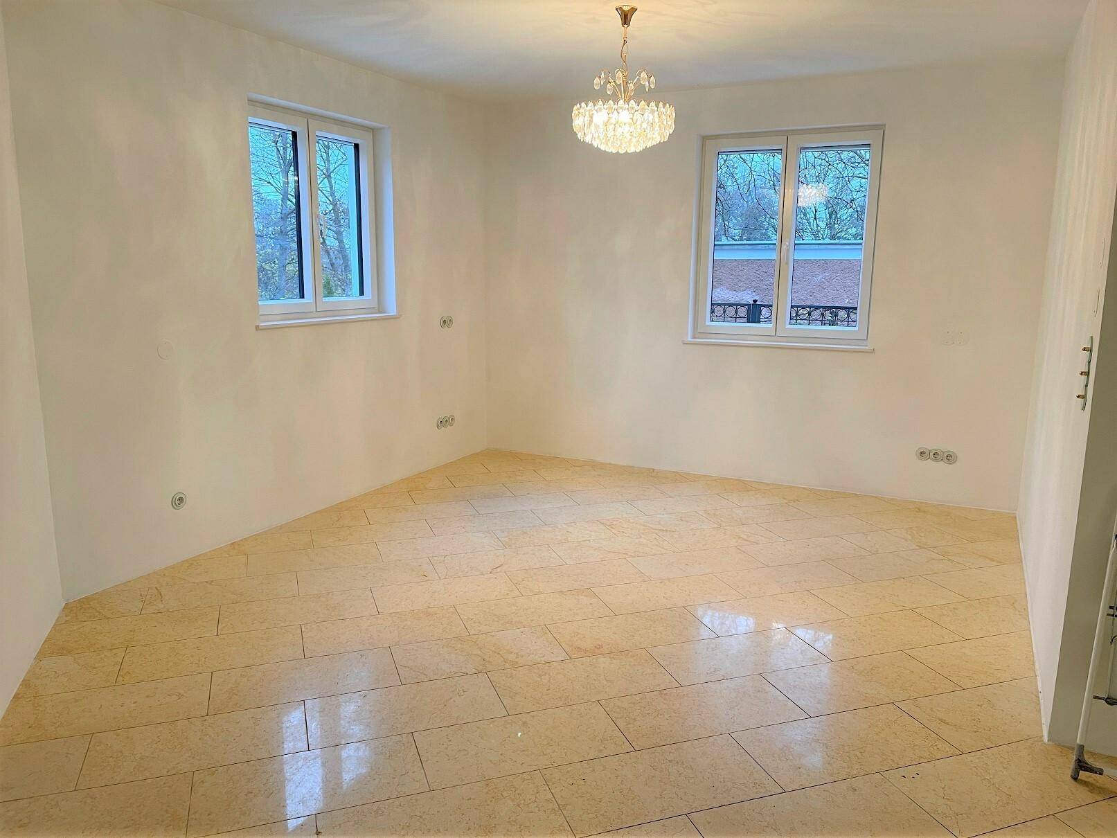 Helles Schlafzimmer mit Fliesenboden und zwei Fenstern, bereit zur individuellen Gestaltung.