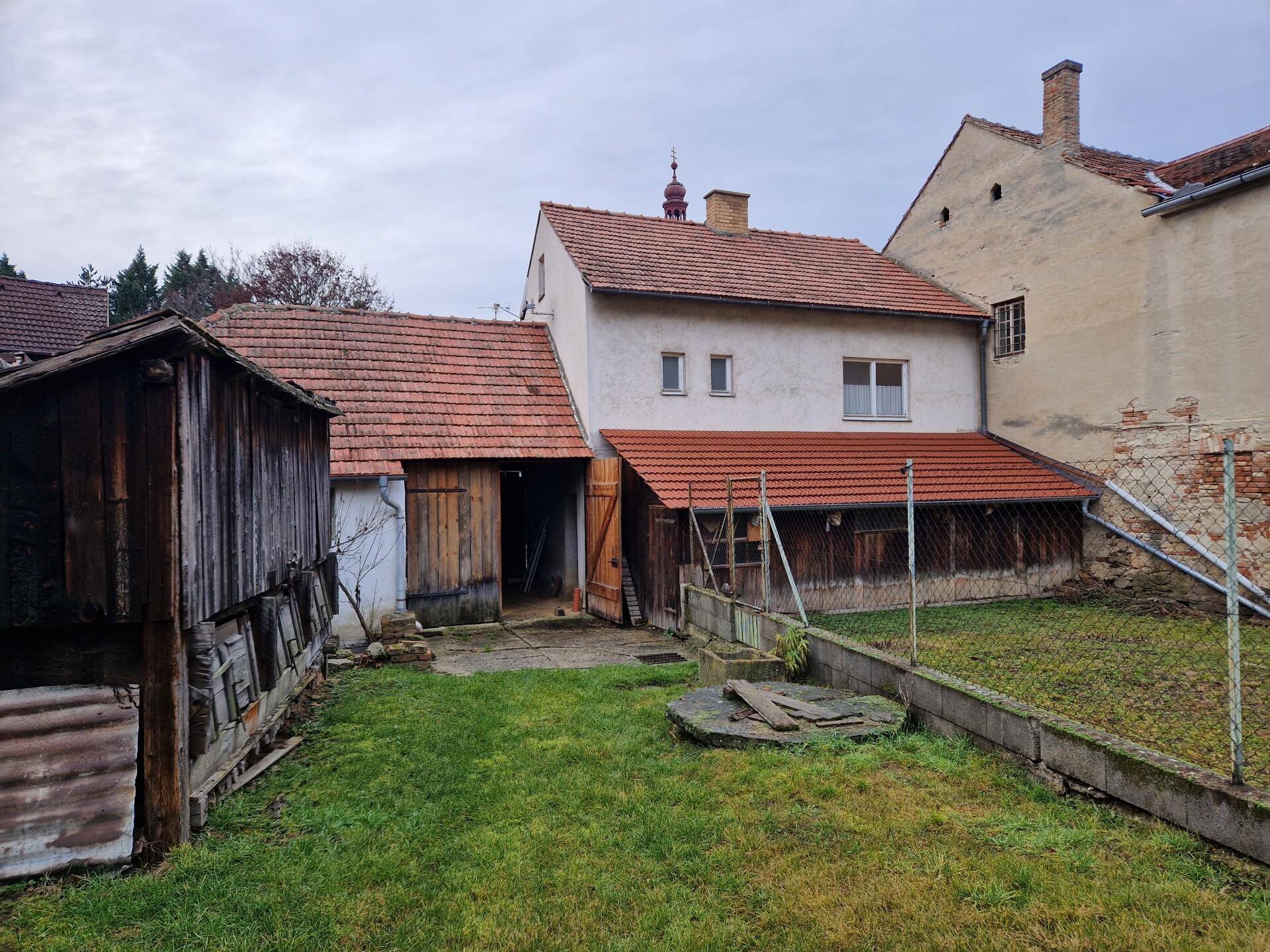 Rückansicht des Hauses mit großem Garten, Nebengebäuden und ländlicher Umgebung.