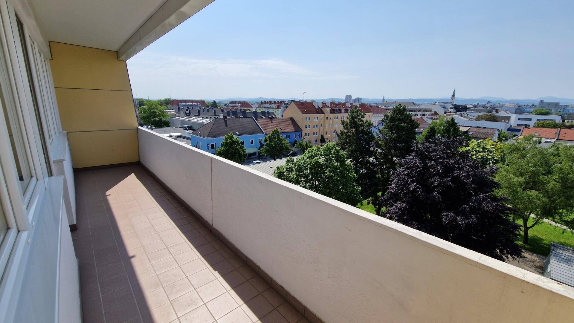 Geräumiger Balkon mit Stadtblick und viel Grün in der Umgebung.