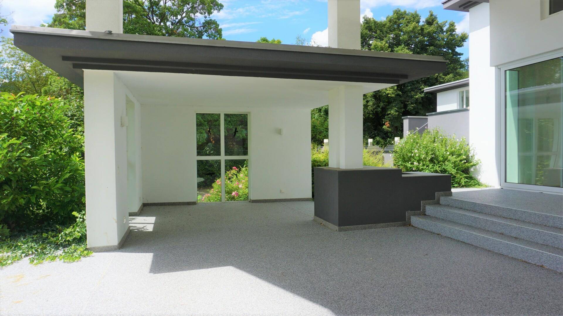 Überdachter Außenbereich mit Säulen und modernem Bodenbelag, ideal als Carport oder Patio.