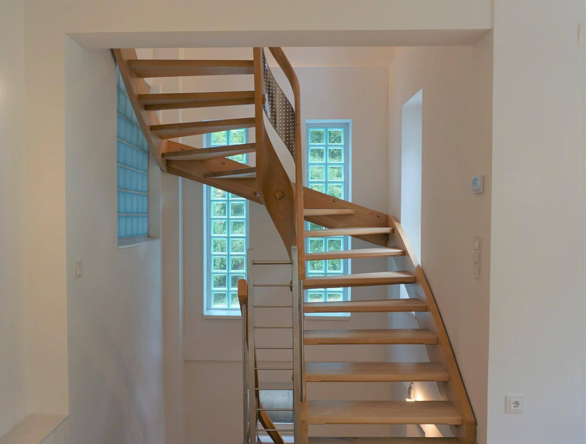Helle Holztreppe mit Glasbausteinfenstern, die für natürliches Licht im Treppenhaus sorgen.
