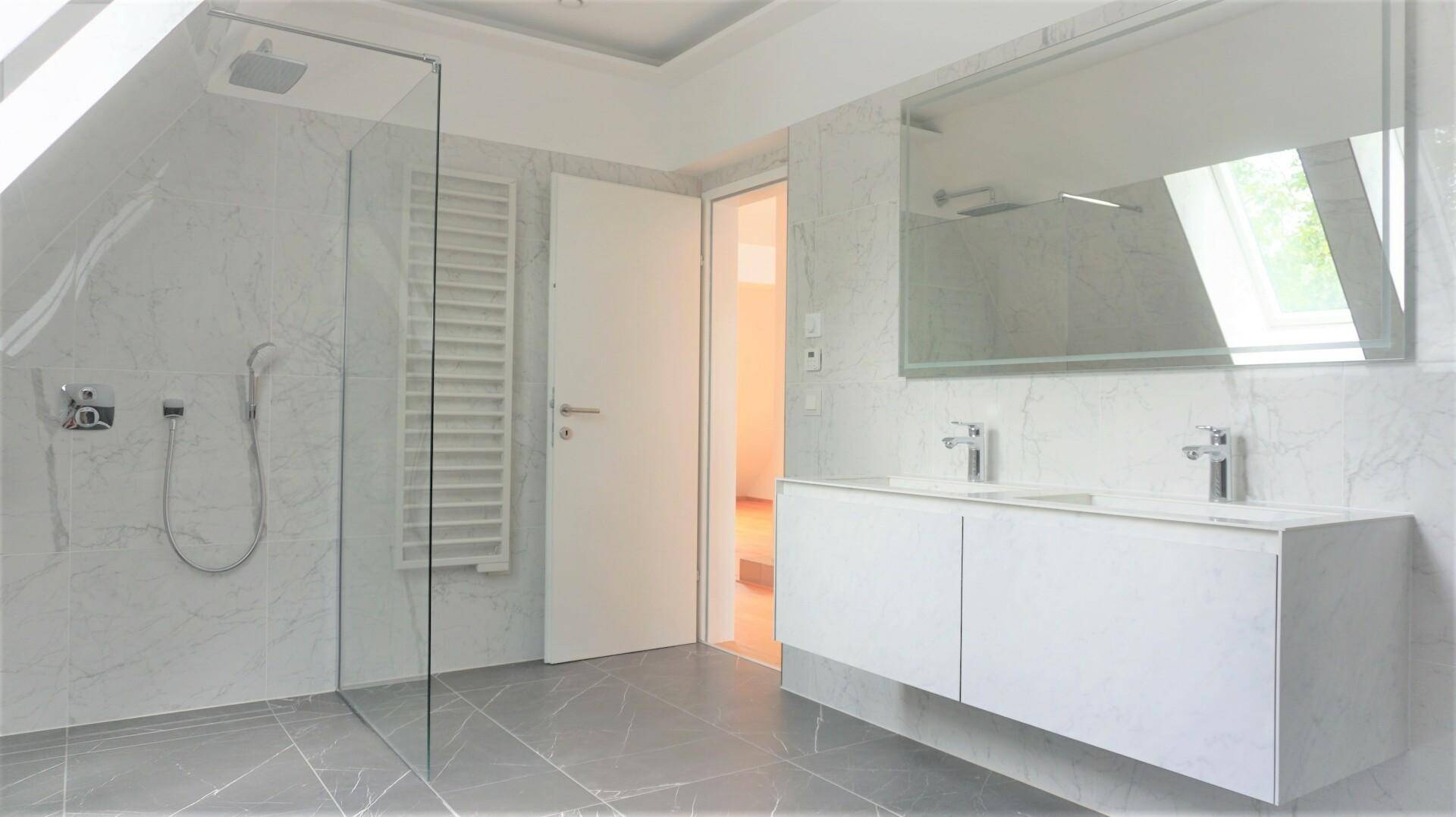 Modernes Badezimmer mit Marmorfliesen, Doppelwaschbecken, begehbarer Dusche und Dachfenster.