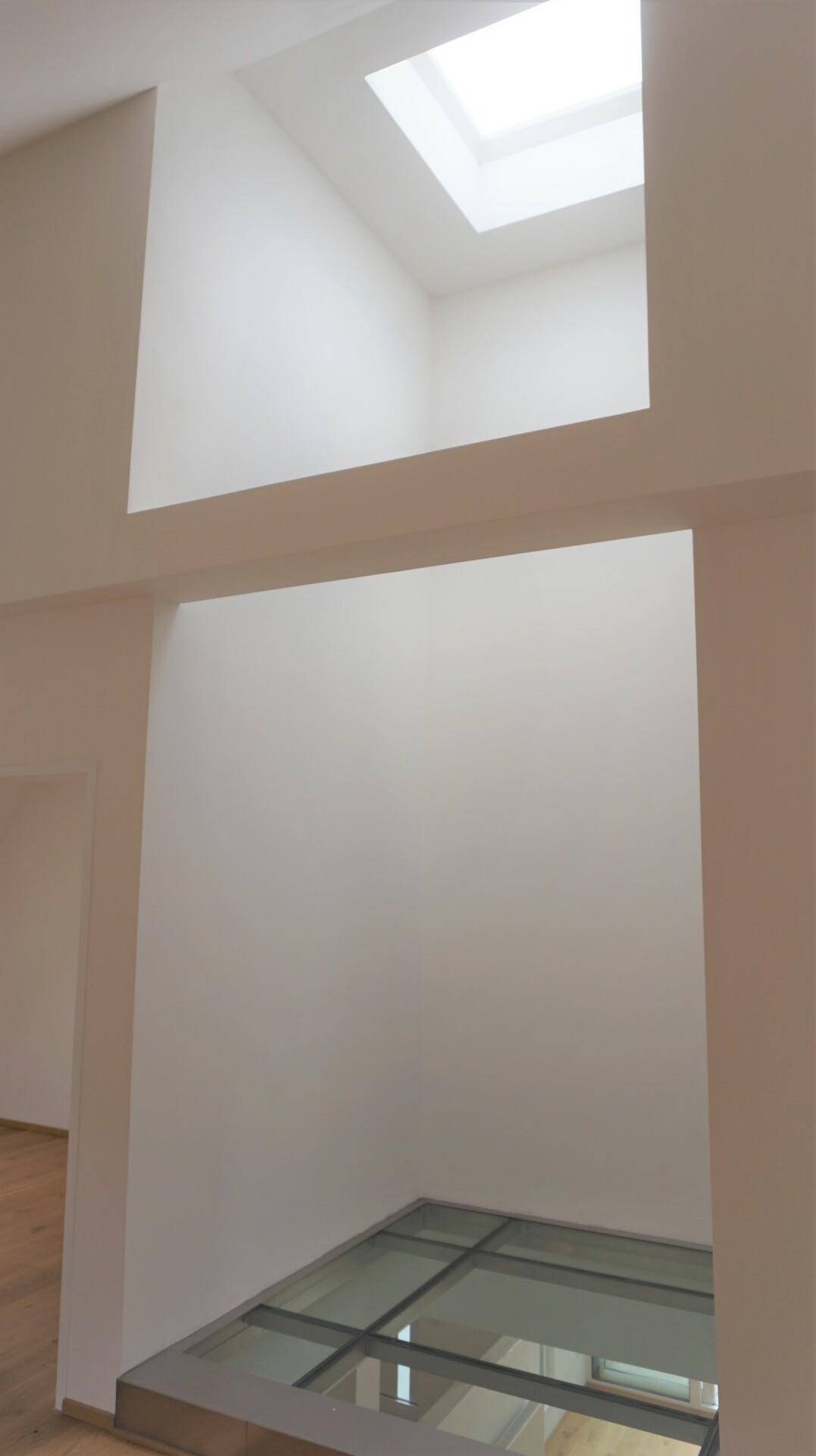 Heller Raum mit Oberlicht und begehbarer Glasfläche im Boden, die für viel Tageslicht sorgt.