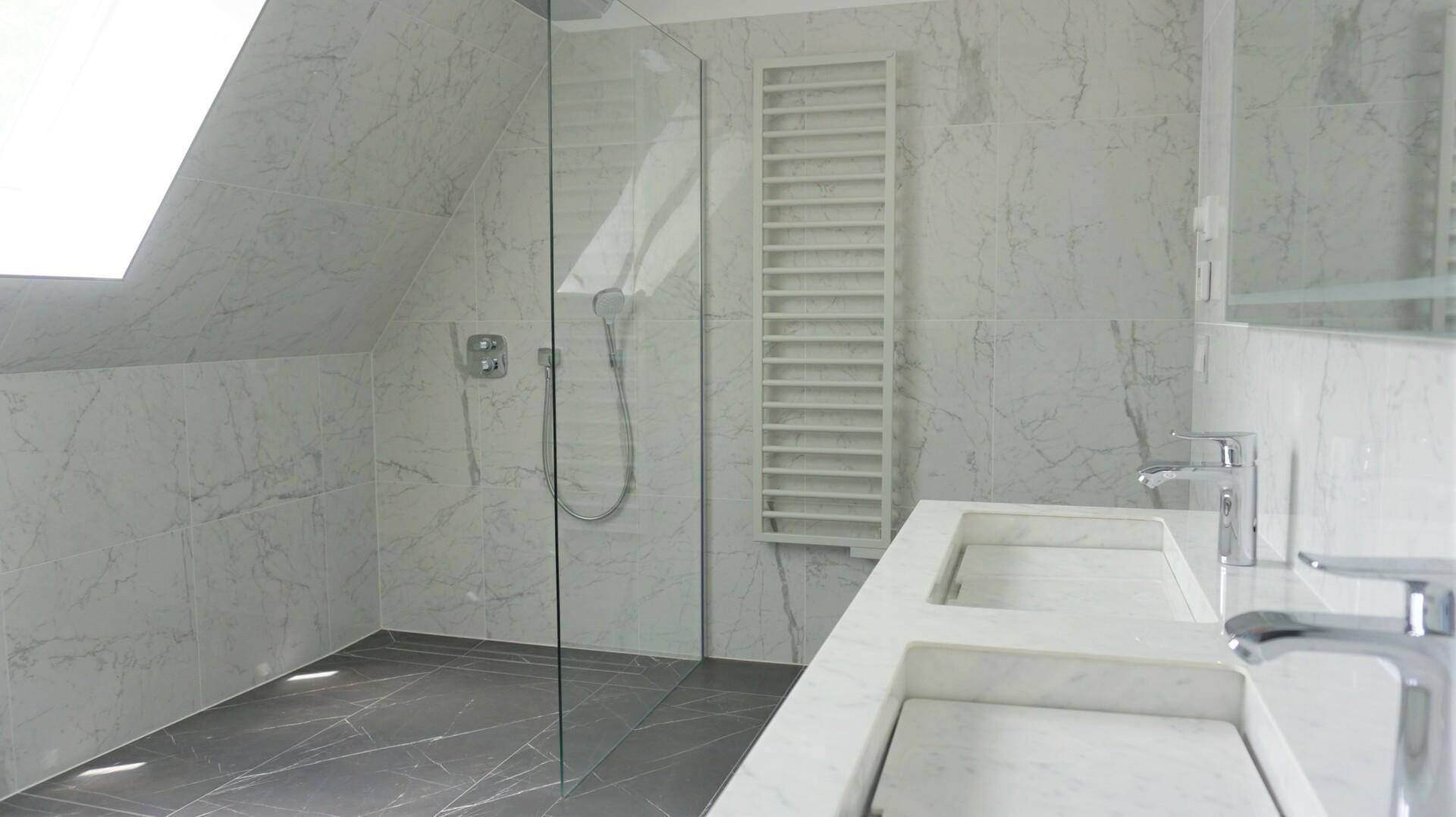 Modernes Badezimmer im Dachgeschoss mit begehbarer Dusche, Doppelwaschbecken und Marmorfliesen.