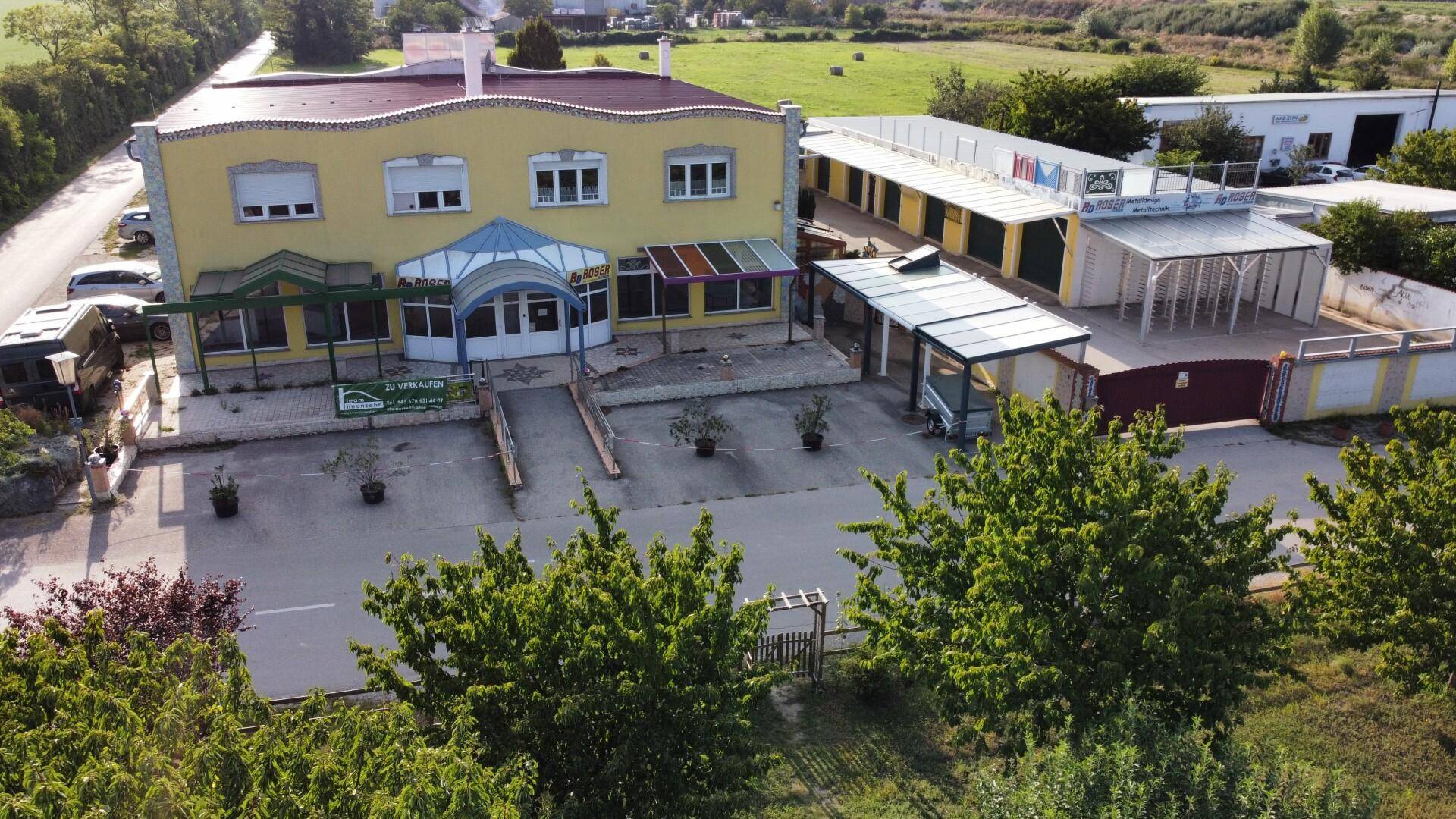 Luftaufnahme des weitläufigen Anwesens mit Hauptgebäude, Nebengebäuden und großzügigen Außenflächen in ländlicher Umgebung.