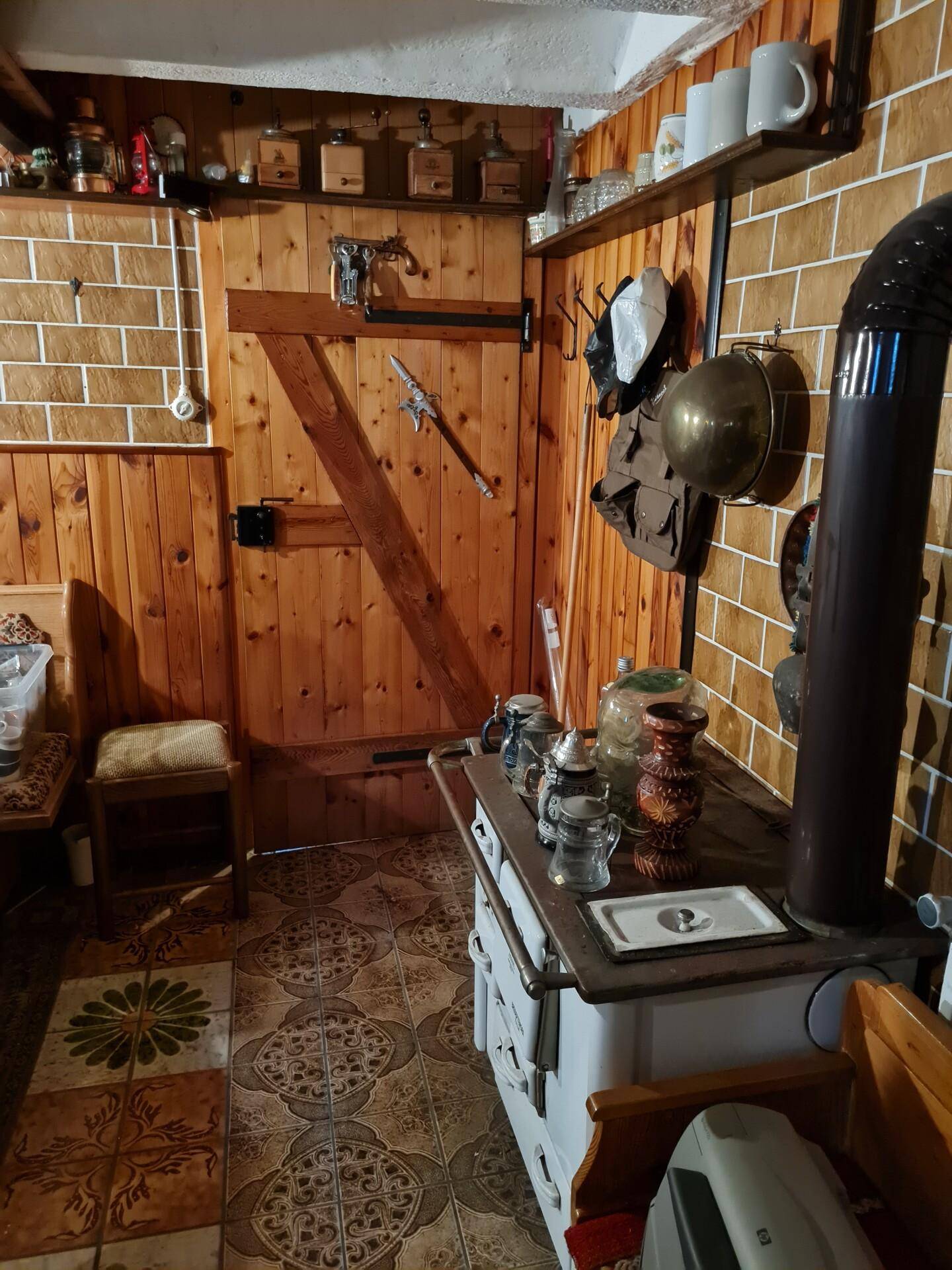 Kellerraum mit traditionellem Holzofen und rustikaler Einrichtung.