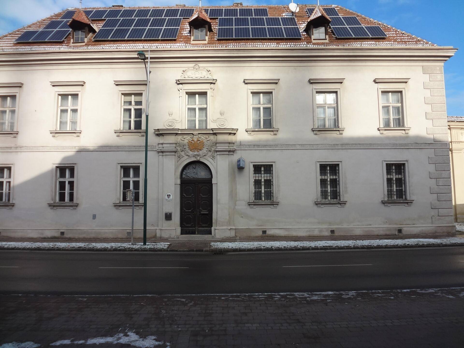 Historisches Gebäude mit einer eleganten Fassade und Solarpaneelen auf dem Dach.