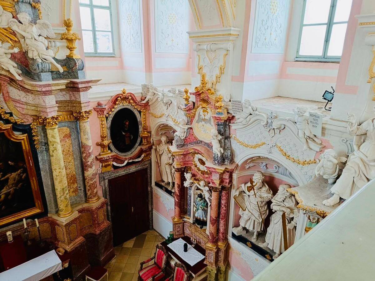 Prunkvoller Innenraum mit reich verzierten Wänden, Statuen und hohen Fenstern, die viel Licht hereinlassen.