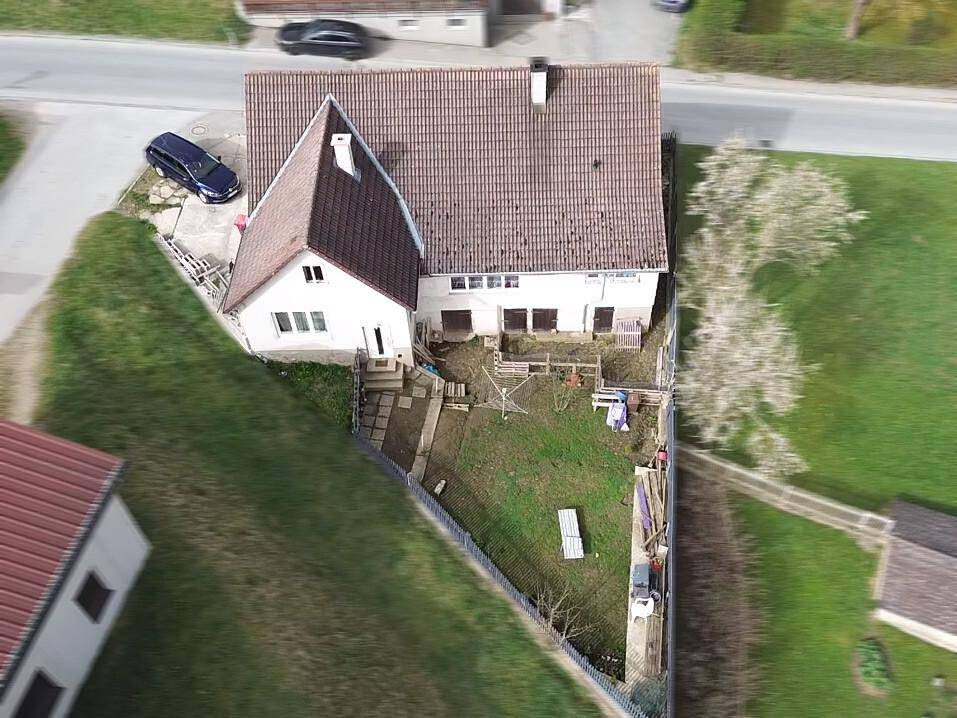 Weitläufige Luftaufnahme des Hauses und des Grundstücks mit umliegender Landschaft.
