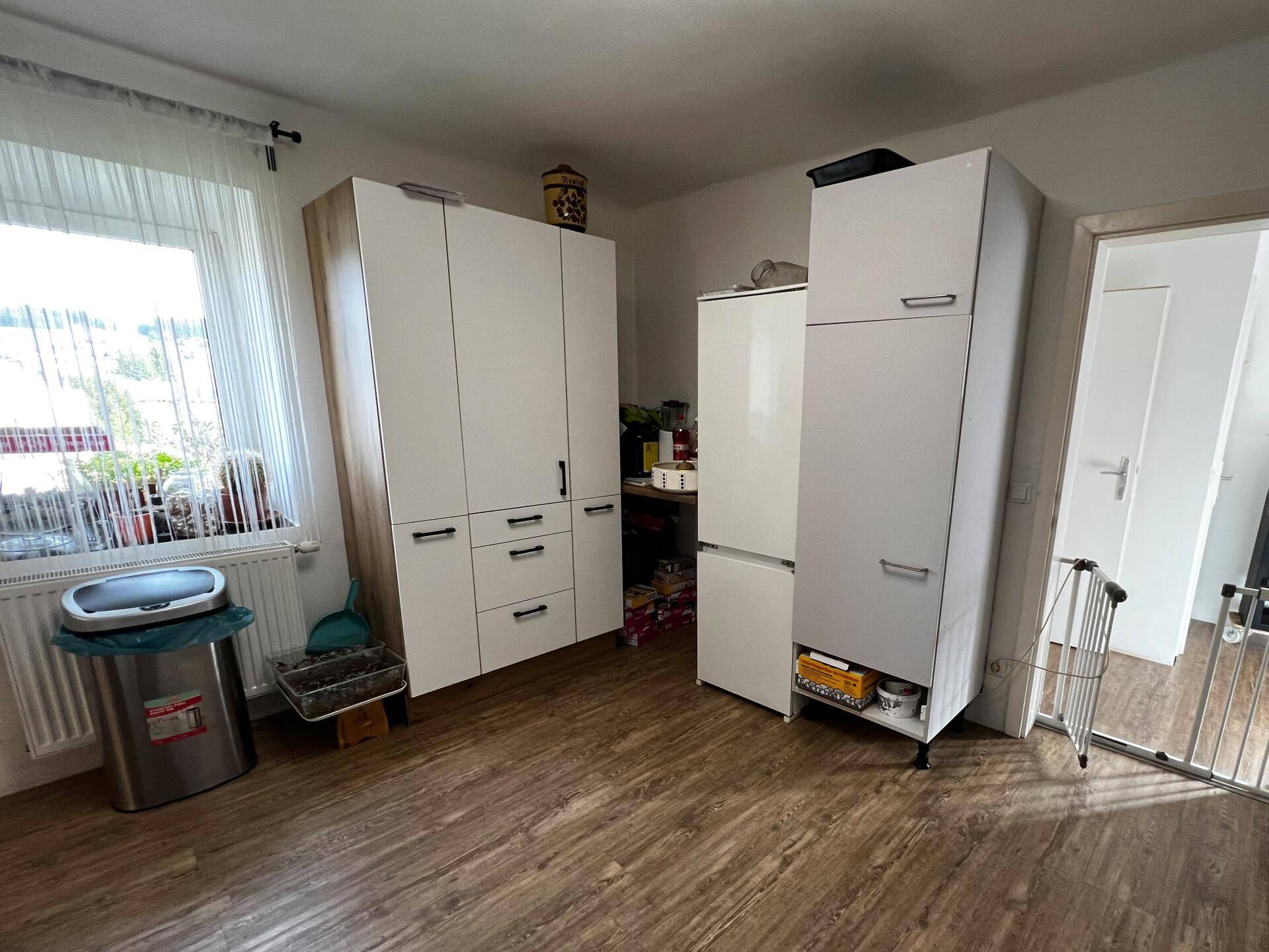 Raum mit Kleiderschrank, Kühlschrank und Fenster, bietet zusätzlichen Stauraum.