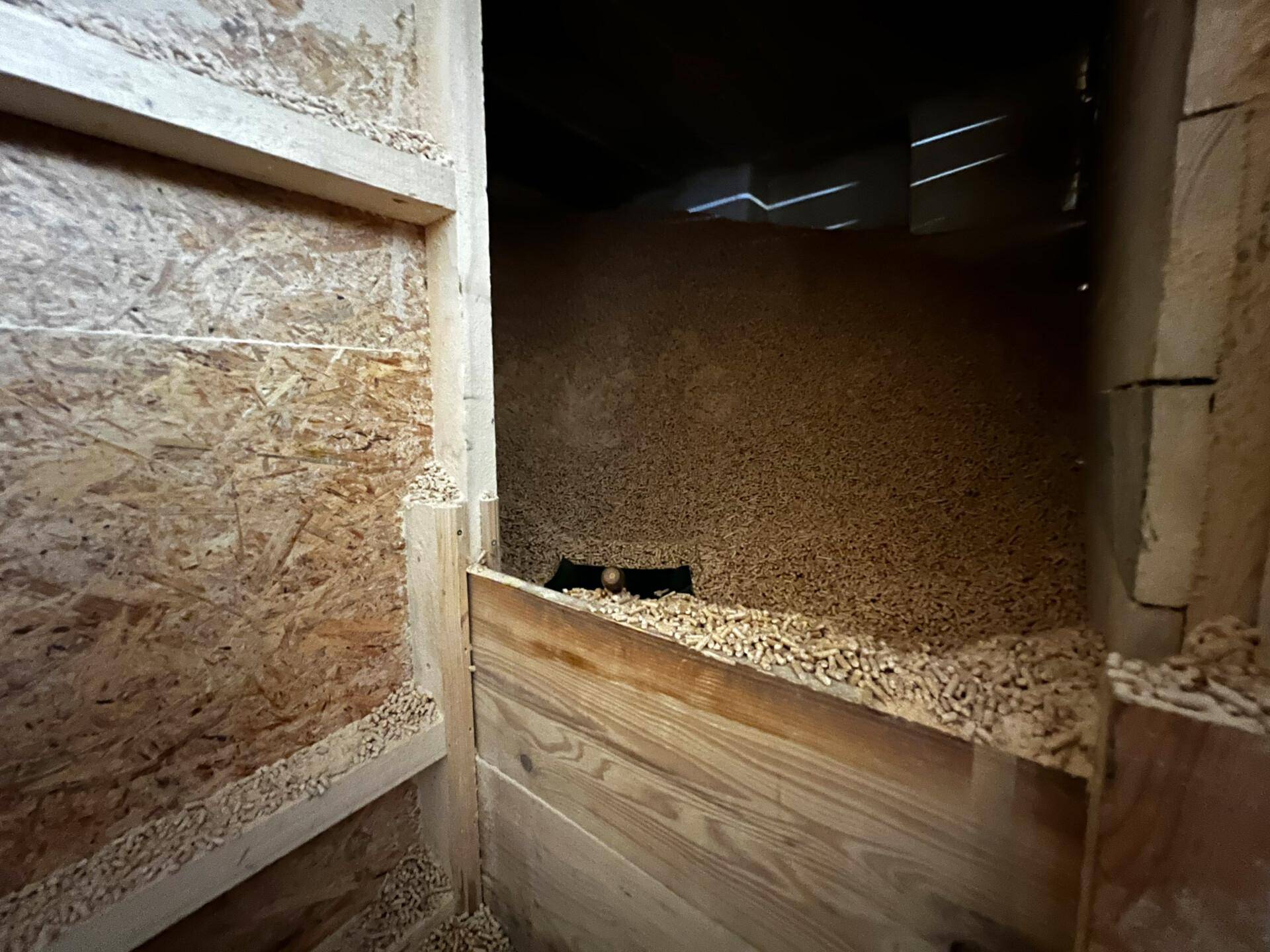 Lagerraum gefüllt mit Holzpellets für die Heizungsanlage des Hauses.