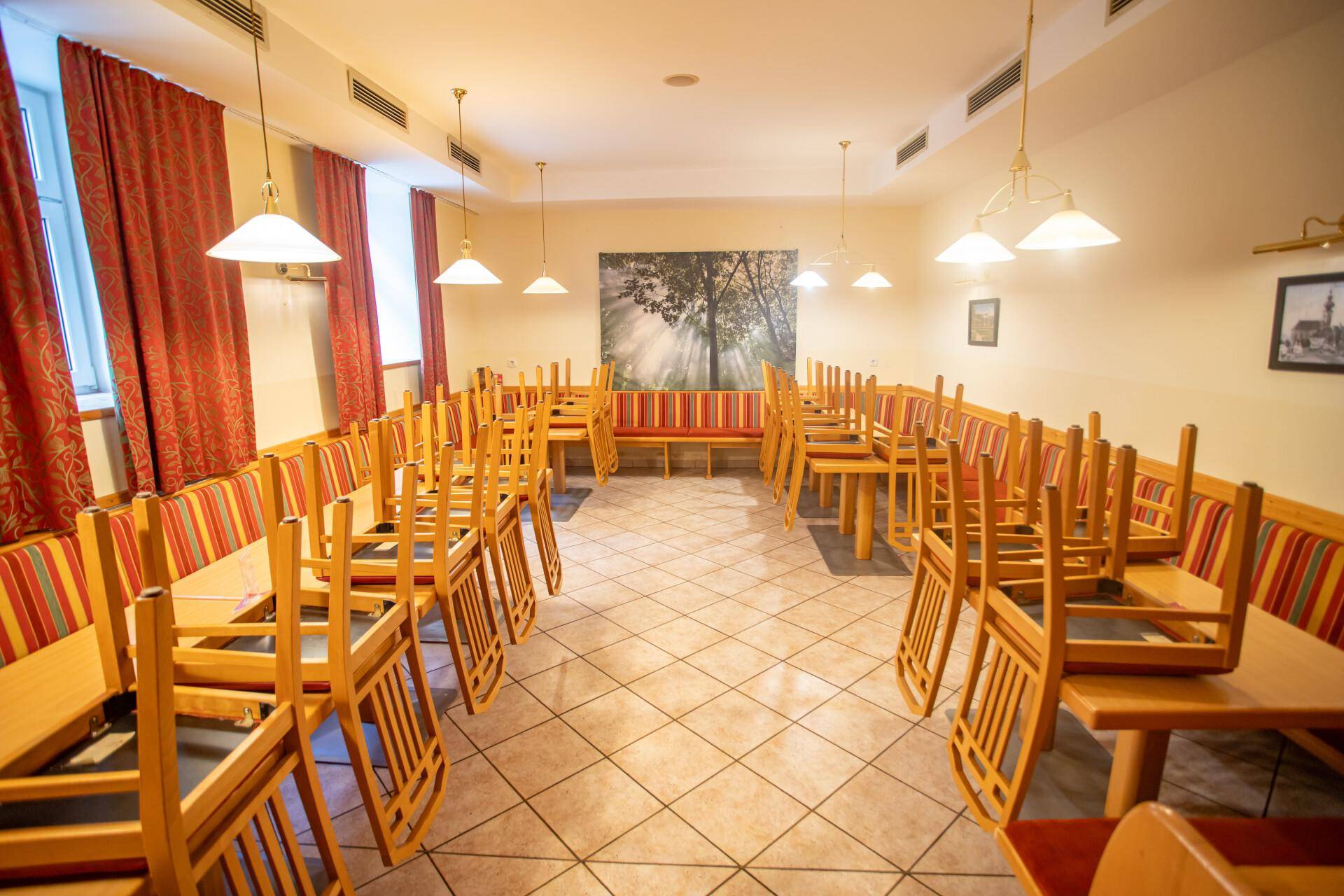 Großer Speisesaal oder Festsaal mit vielen Tischen und Stühlen, bereit für Veranstaltungen und Feiern.
