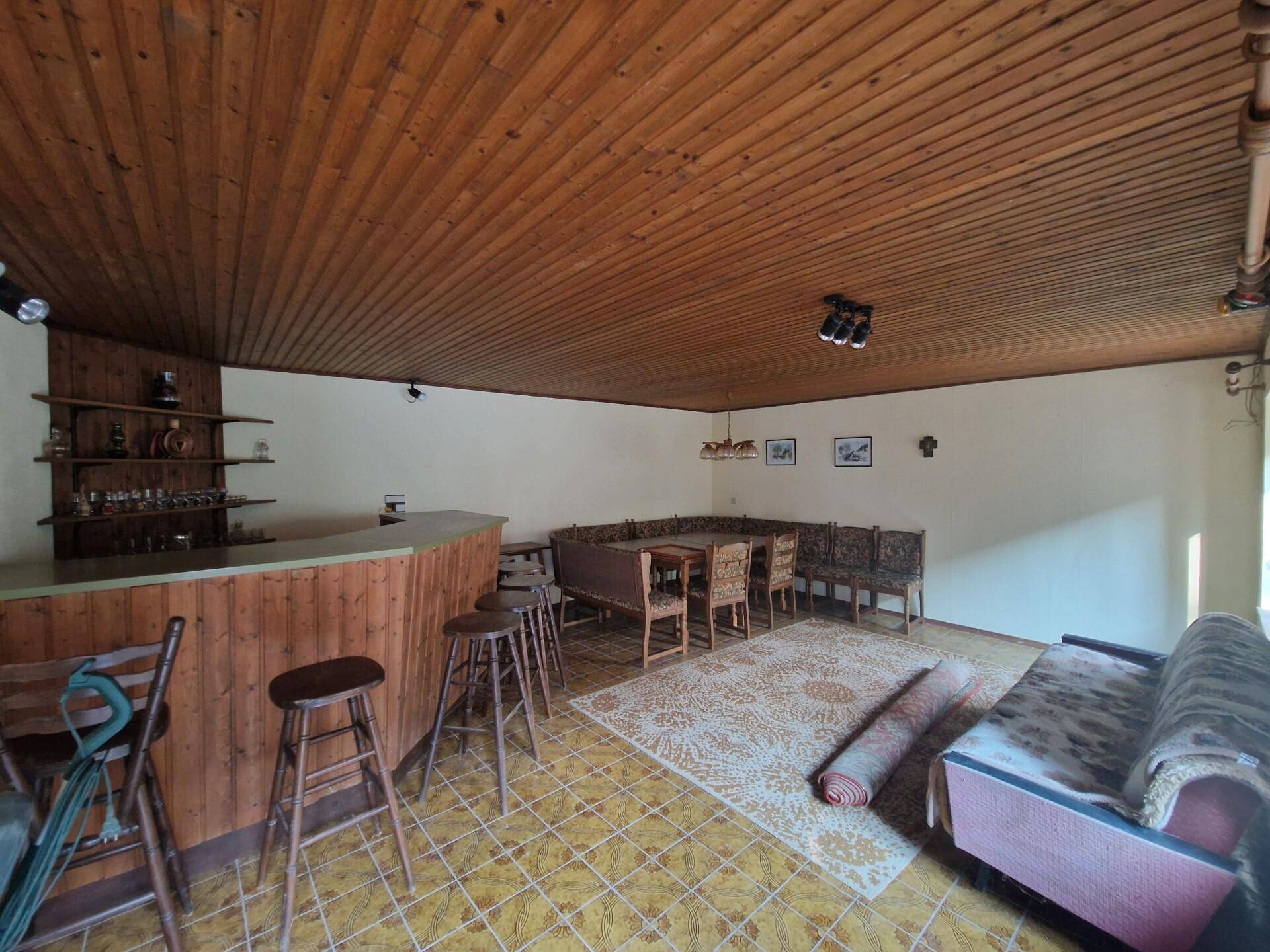 Freizeitraum mit Holzdecke, Bar und Sitzgelegenheiten, ideal für gesellige Runden.