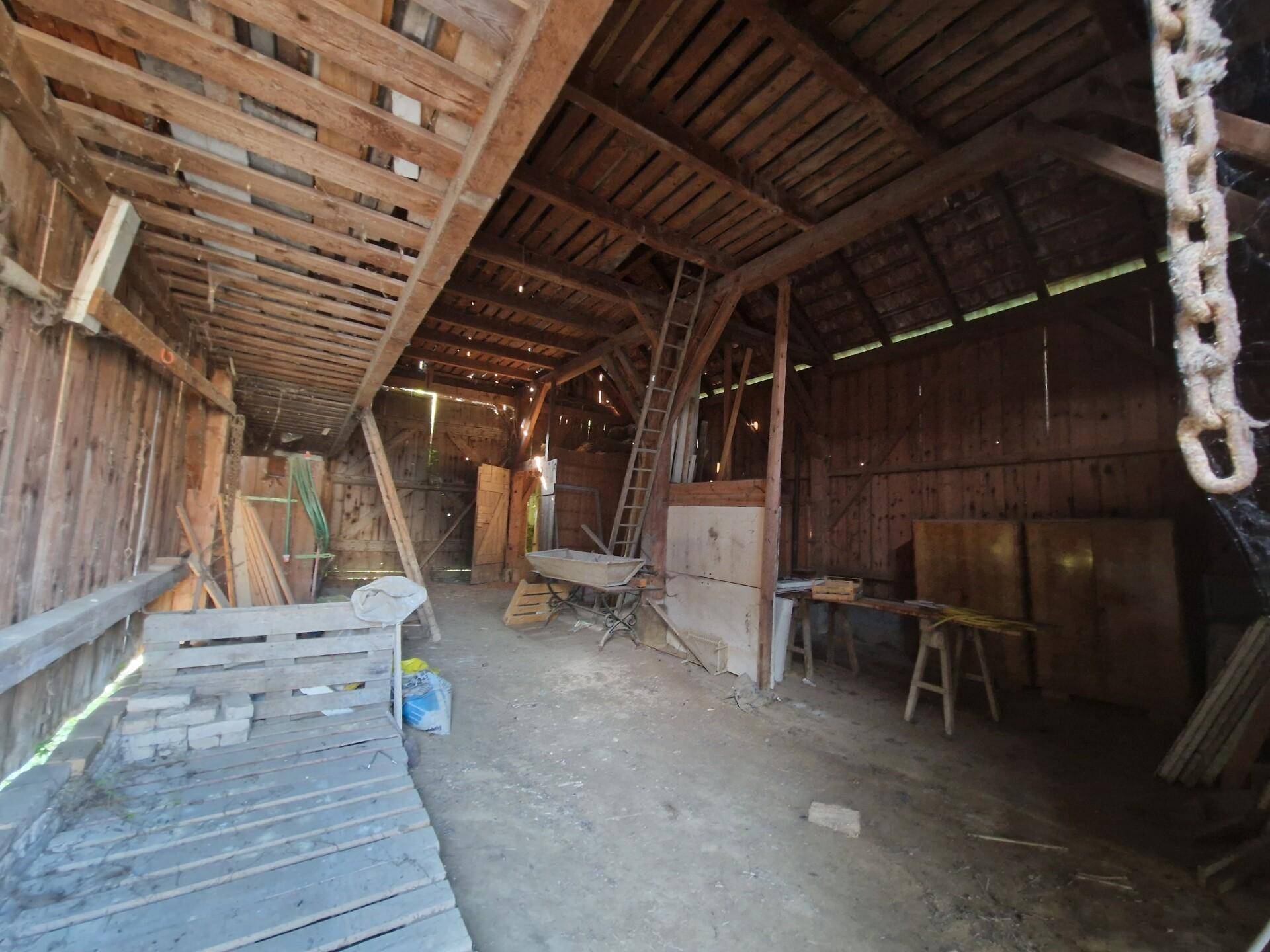 Großer Scheuneninnenraum mit sichtbaren Holzbalken und viel Lagerfläche.