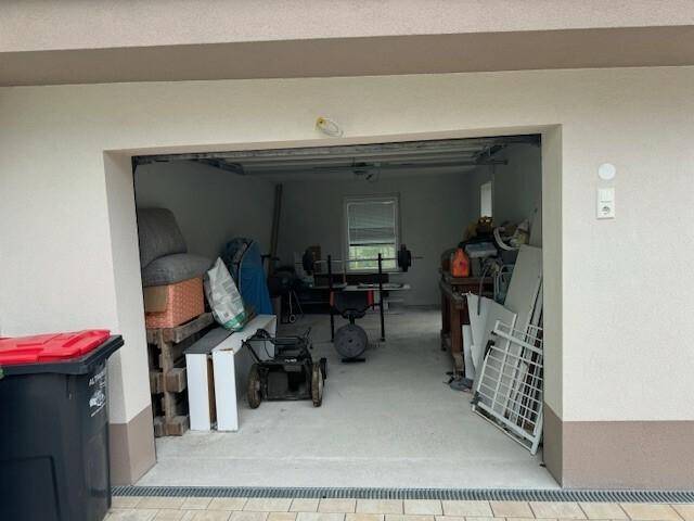 Geräumige Garage mit Lagerfläche und einem Fenster für Tageslicht.