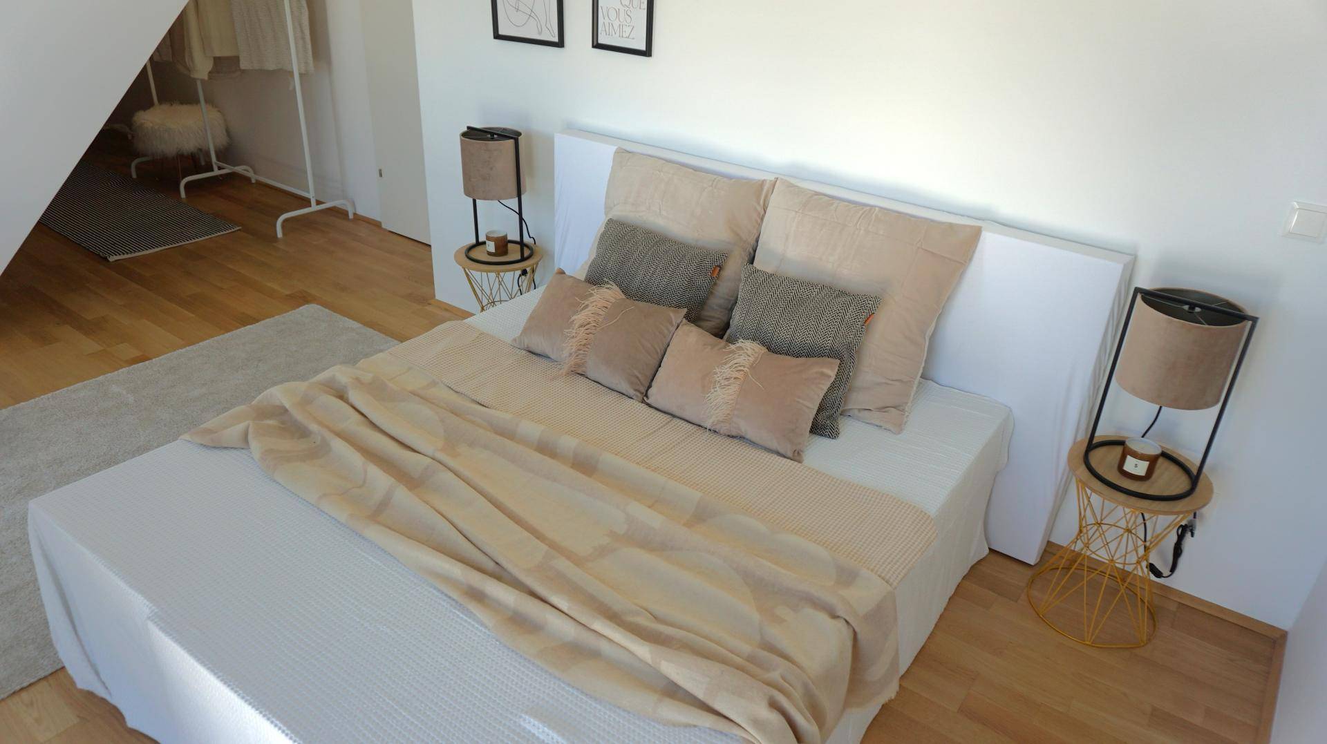 Geräumiges Schlafzimmer mit Doppelbett, Holzboden und einer gemütlichen Dachschräge.
