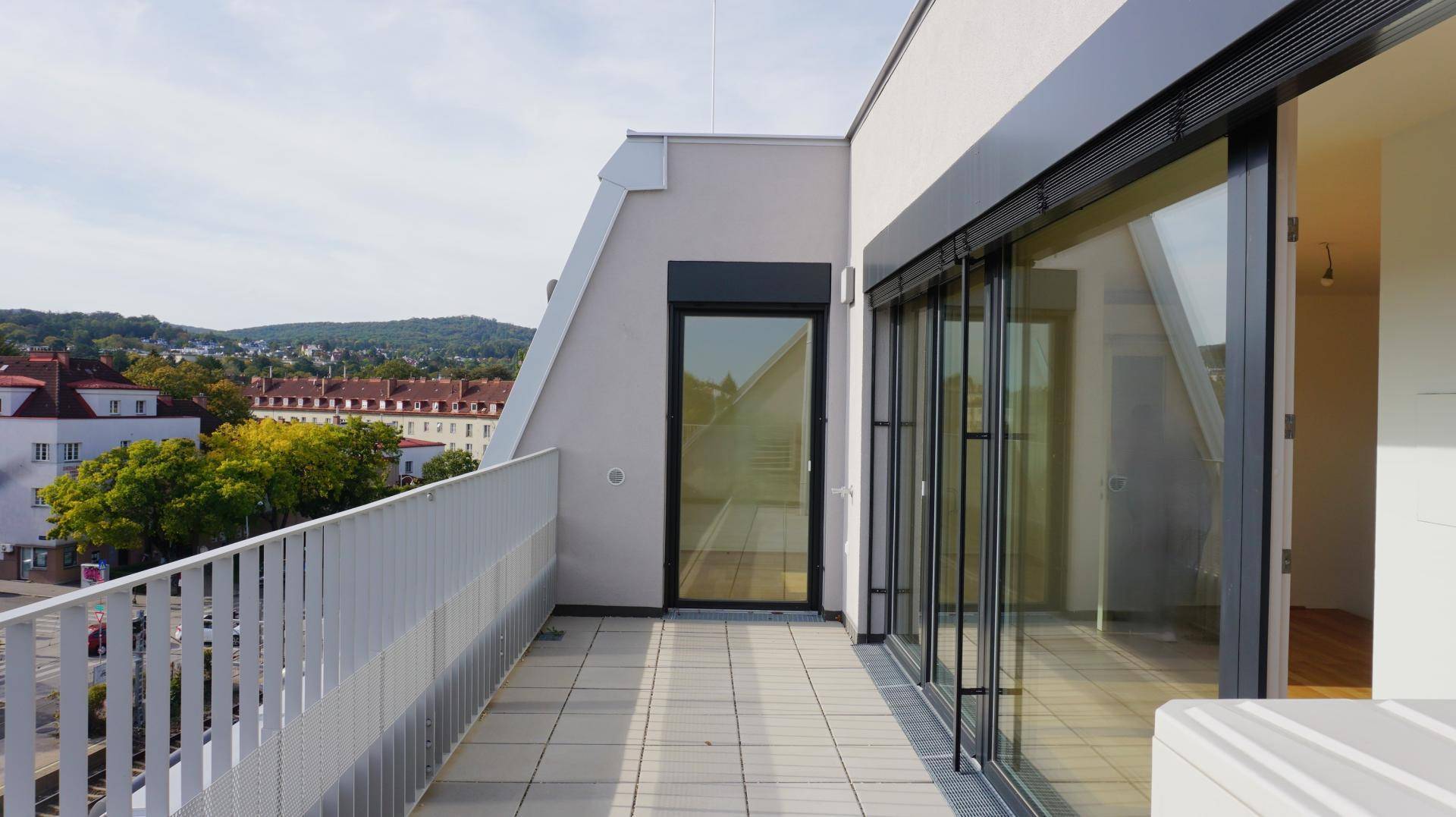 Balkon mit moderner Brüstung und Panoramablick auf die Stadt und die umliegende Landschaft.
