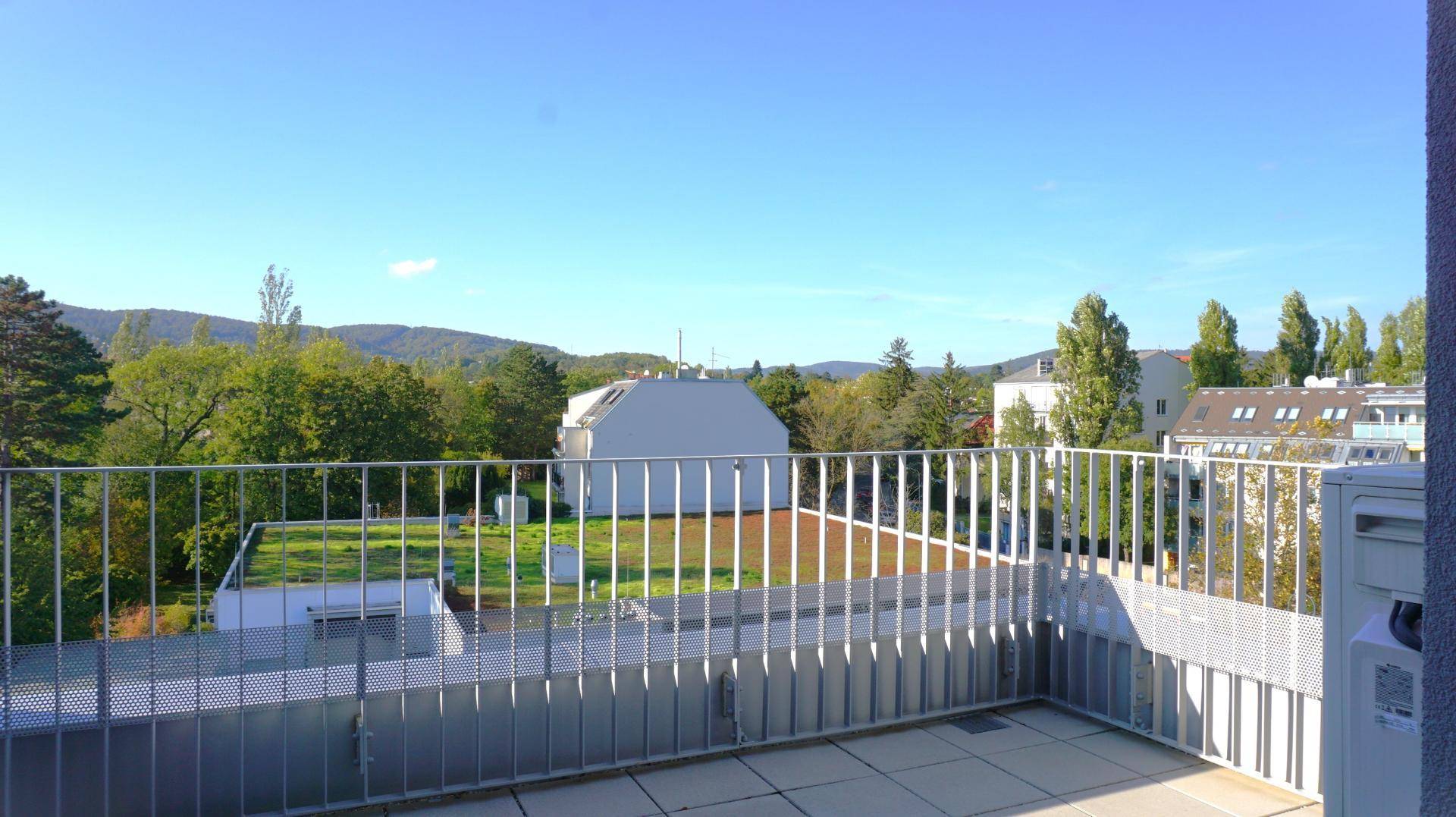 Geräumiger Balkon mit Metallgeländer und weitem Blick ins Grüne und auf die Umgebung.