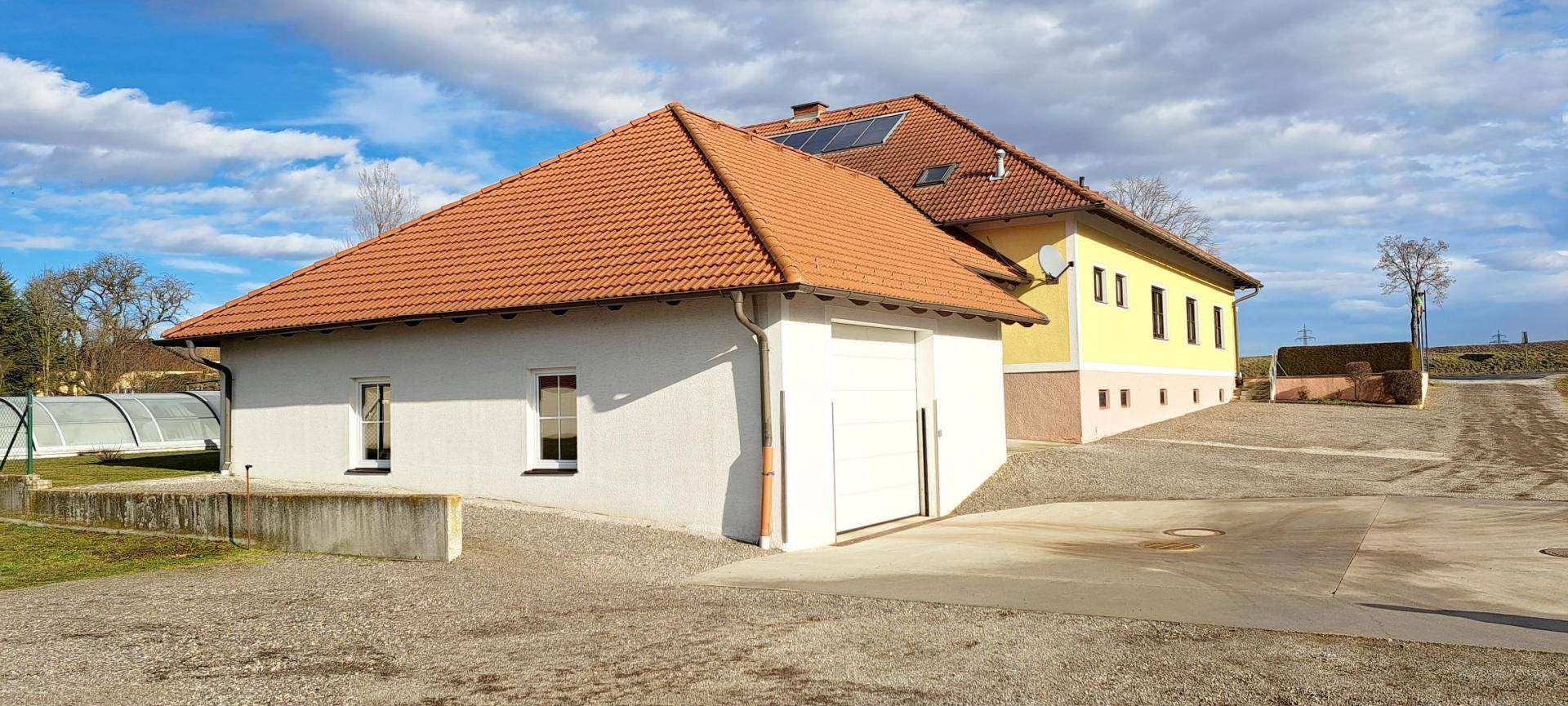 Rückansicht des Anwesens mit Garage, Nebengebäude und Zufahrt.