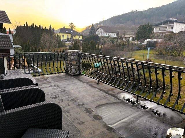 großer Balkon mit Sonnenuntergang hinter dem Gfieder