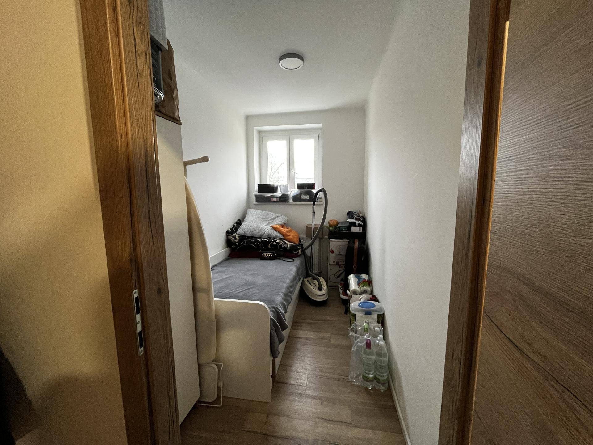 Kleines Zimmer mit Einzelbett, Fenster und Stauraum, ideal als Gäste- oder Kinderzimmer.