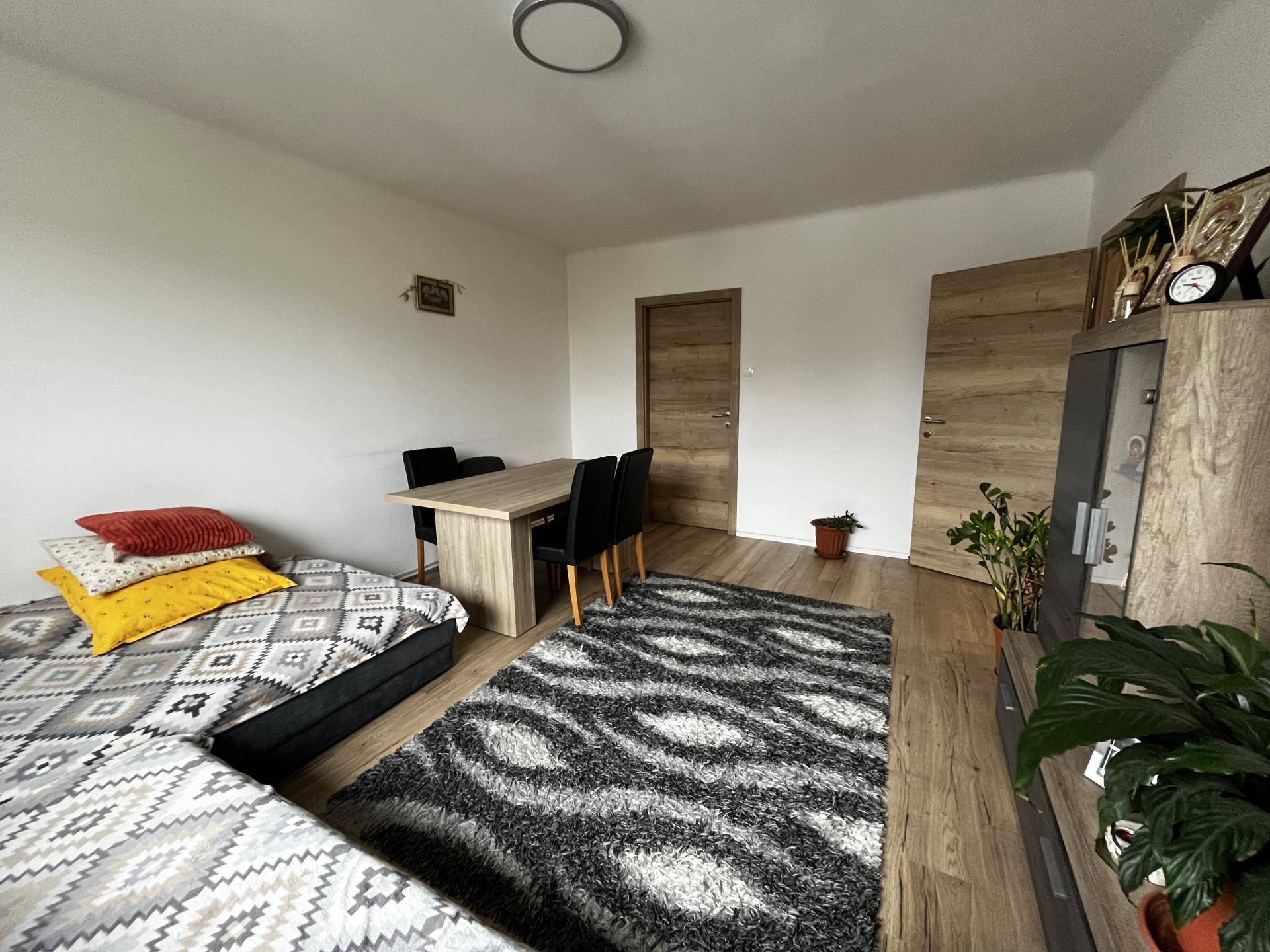 Geräumiger Wohn-Essbereich mit Sofa, Esstisch und Holzoptikboden, ideal für geselliges Beisammensein.