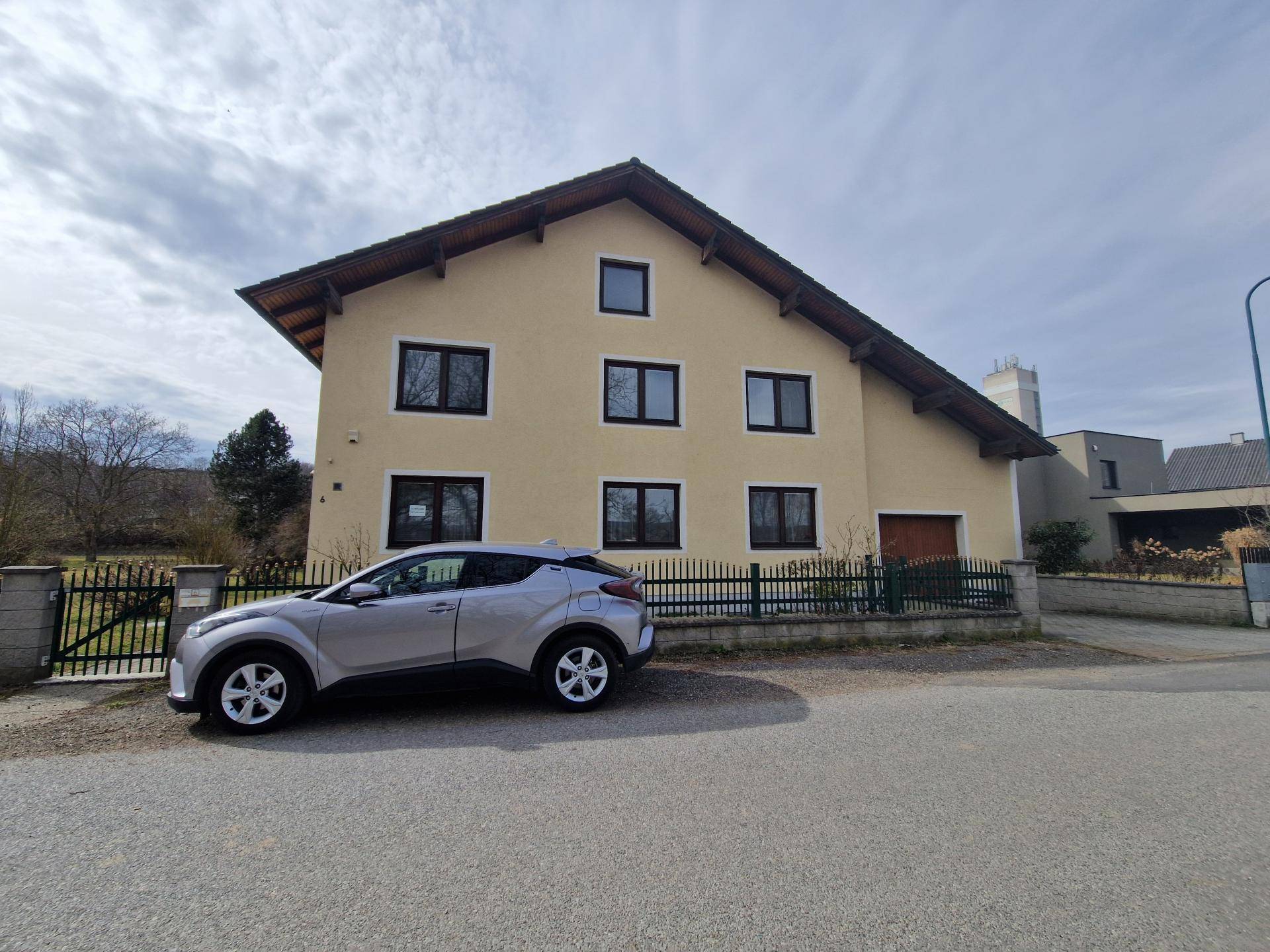 Ansicht des Hauses von der Straße mit einem geparkten Auto davor.
