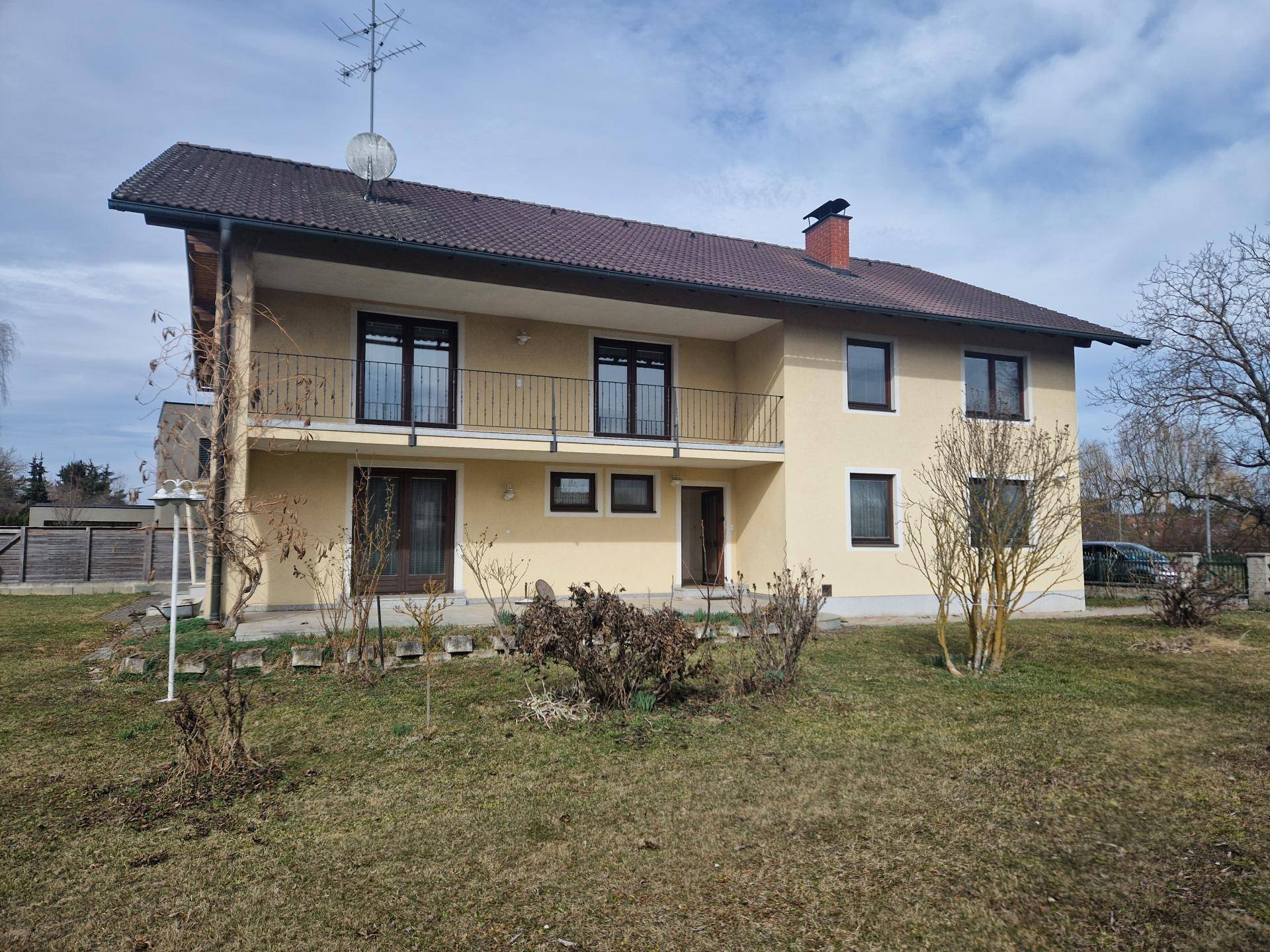 Rückansicht des Hauses mit Balkonen und Gartenbereich.