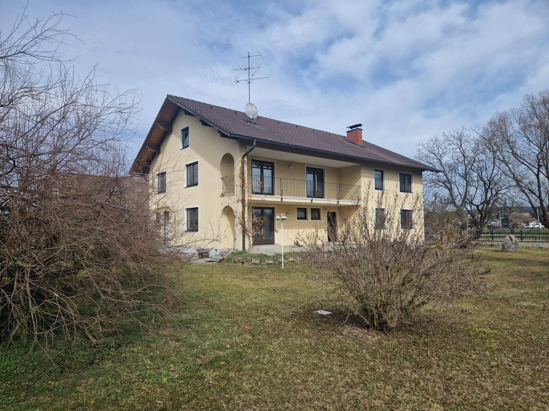 Rückansicht des Hauses mit Balkonen und weitem Blick in den Garten.
