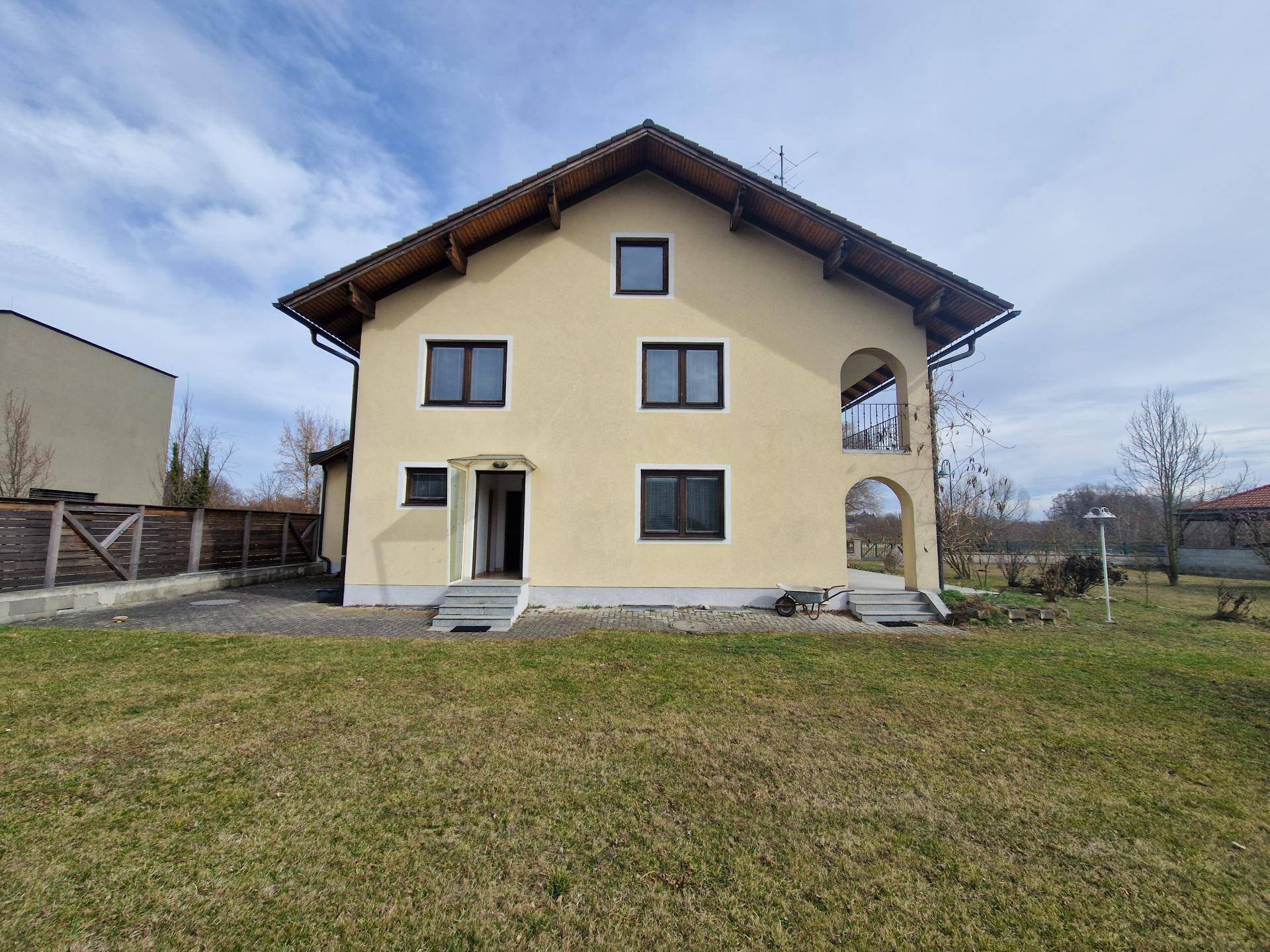 Vorderansicht des Hauses mit gepflegtem Rasen und Eingangsbereich.