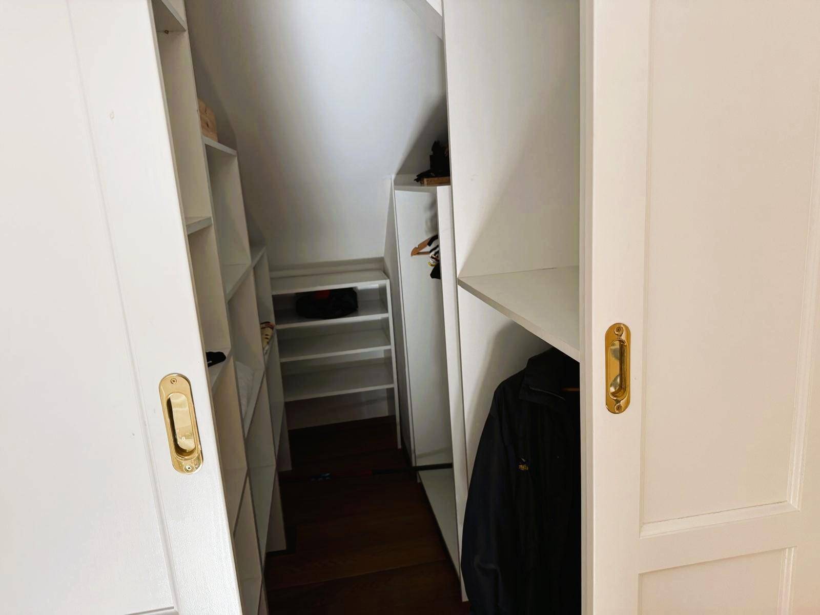 Praktischer begehbarer Kleiderschrank mit vielen Regalen und ausreichend Stauraum.