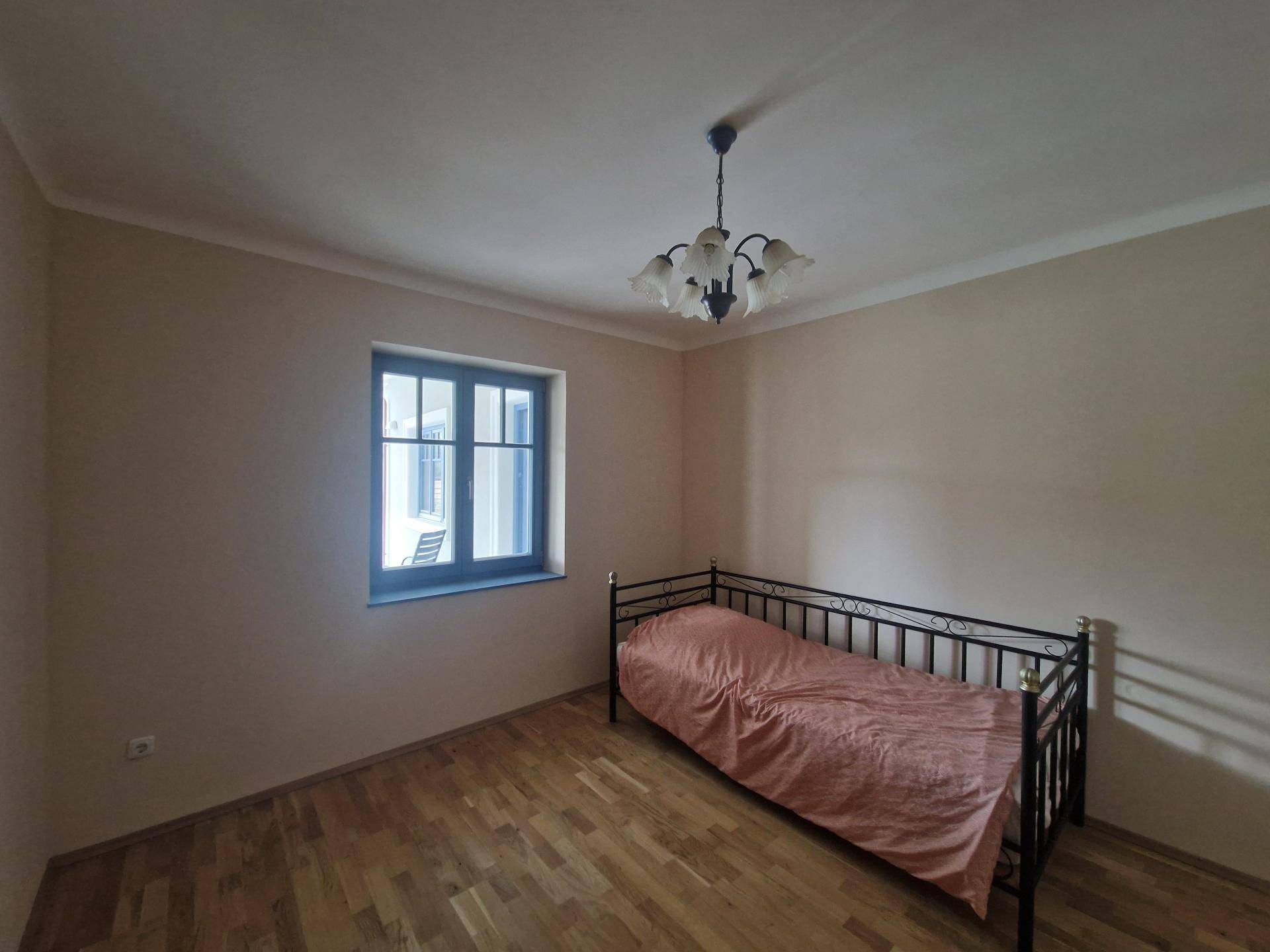 Helles Schlafzimmer mit Holzboden und Einzelbett, ideal als Kinder- oder Gästezimmer.