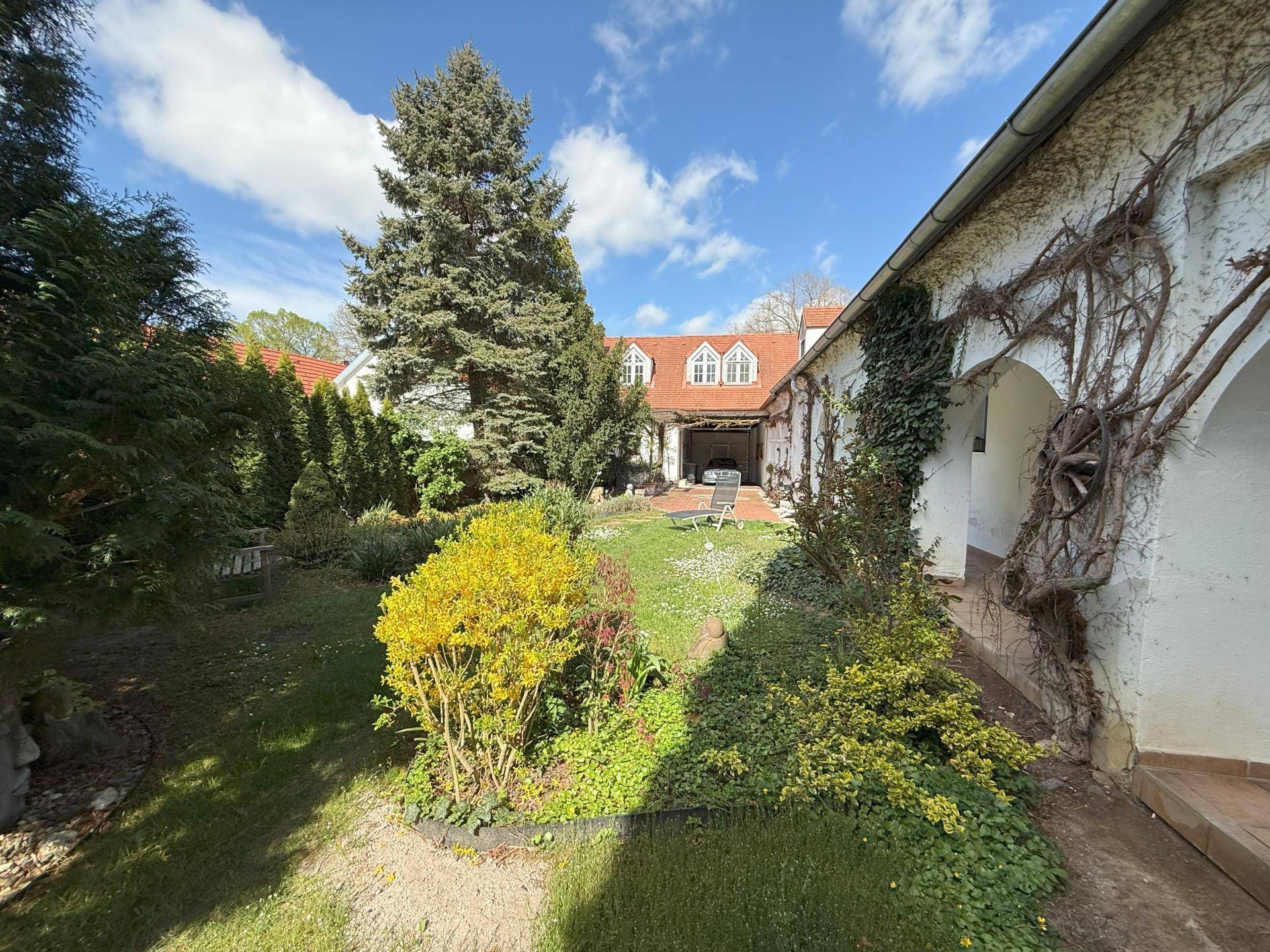 wunderschön bepflanzter Innenhof mit Laube
